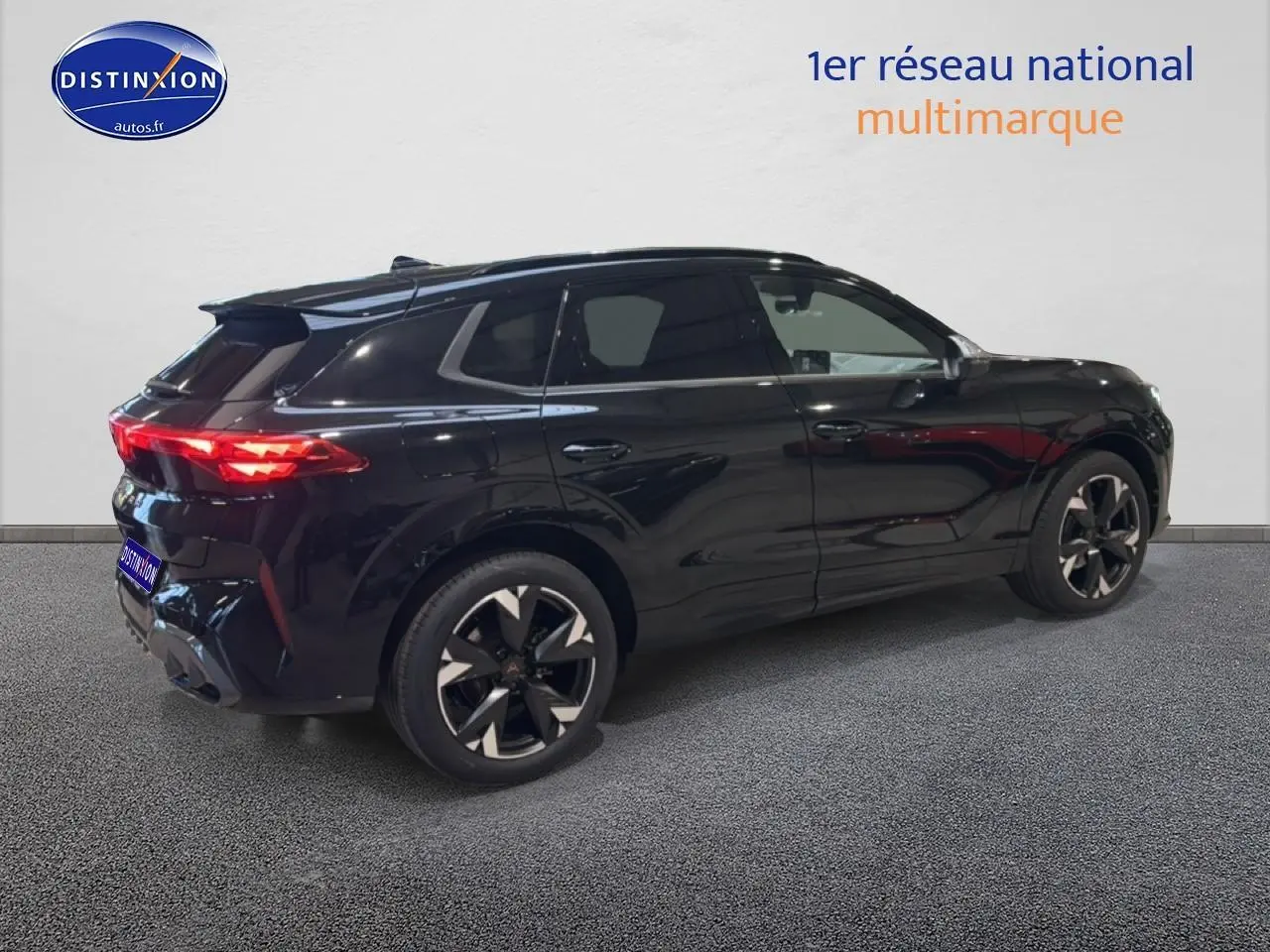 Vue 3/4 arrière droite d'un SUV CUPRA TERRAMAR noir brillant avec jantes 19 pouces et feux arrière LED allumés.