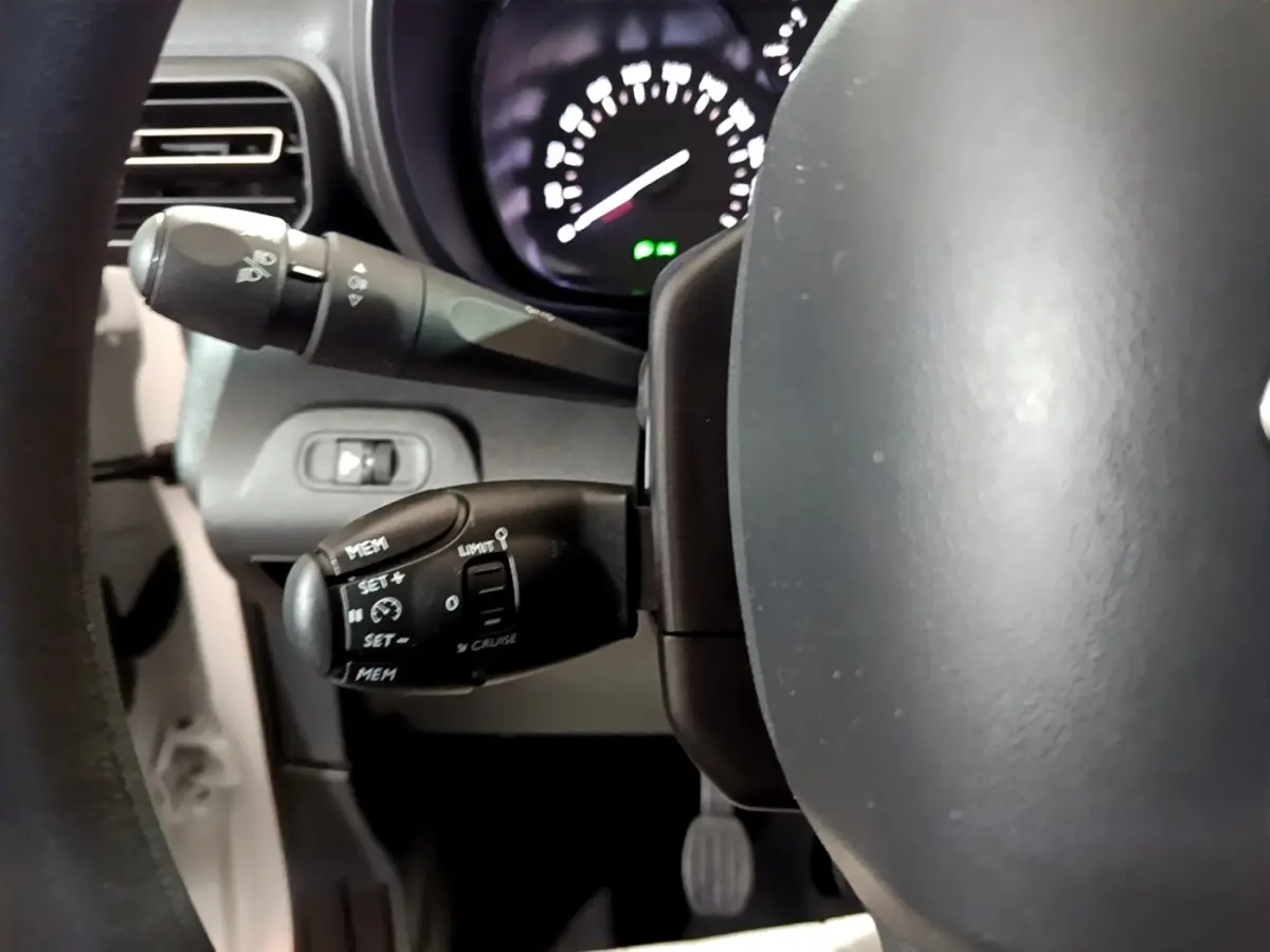 Gros plan sur le volant et les commandes de régulateur de vitesse du Citroën Berlingo blanc, version XL PureTech 2019.