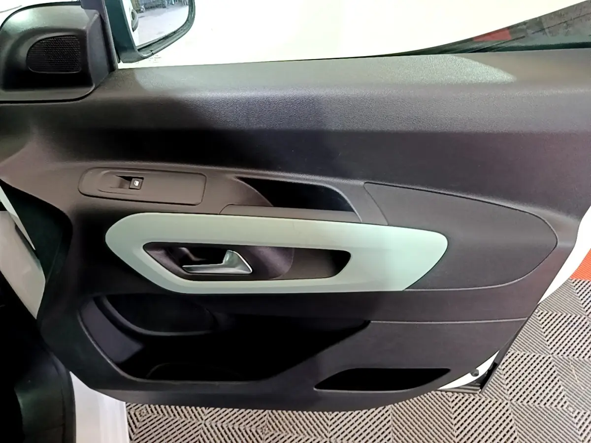 Vue rapprochée de la porte avant gauche blanche du Citroën Berlingo XL 2019 avec poignée intérieure grise.