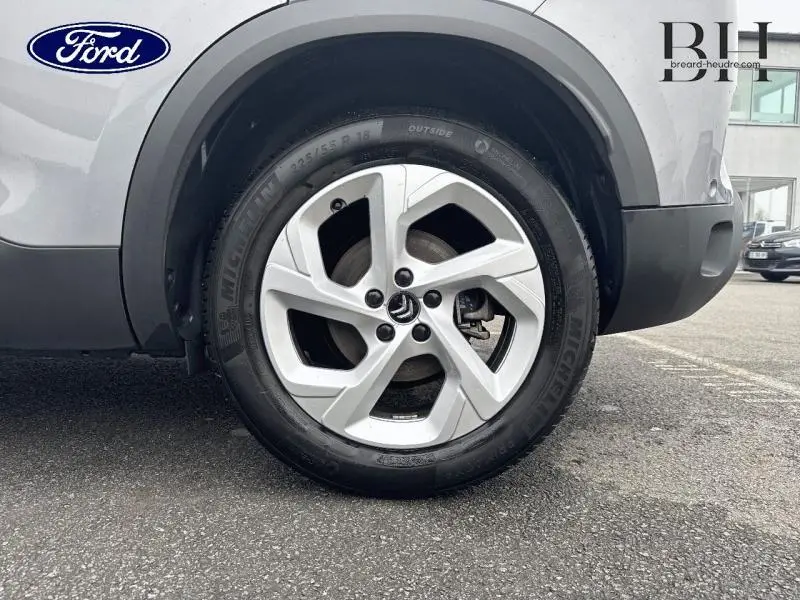 Gros plan sur la roue avant droite avec jante alu du Citroën C5 Aircross Gris Acier 2023.