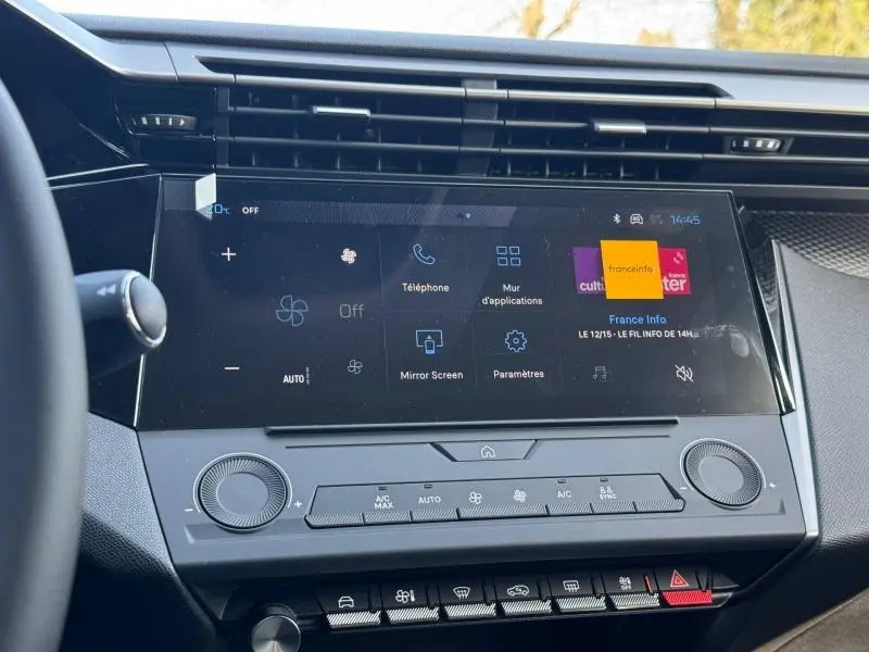 Vue rapprochée de l’écran tactile central et des commandes de climatisation dans l’habitacle d’une Peugeot 308 blanche.