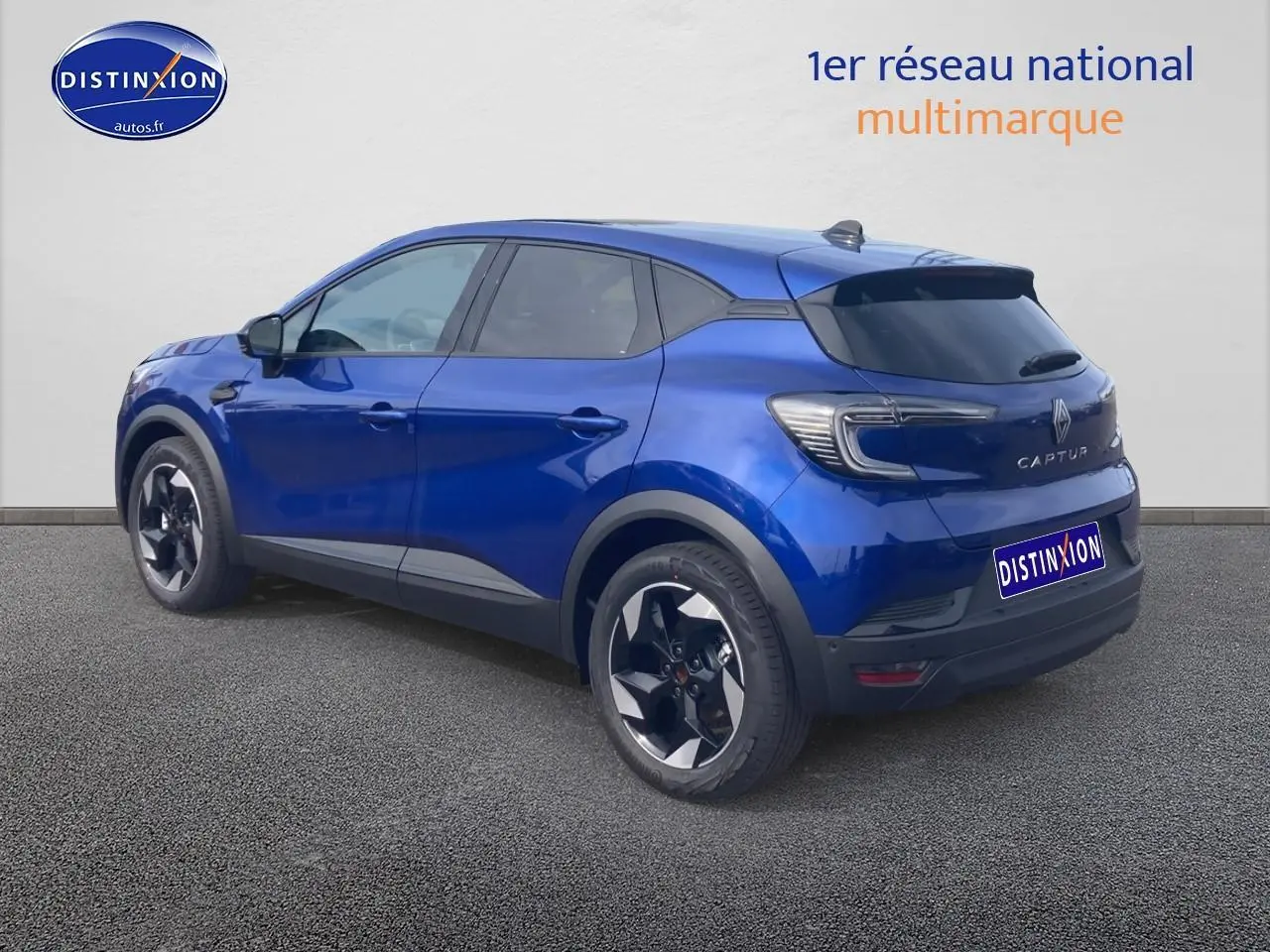Renault Captur bleu iron vu en 3/4 arrière droit, avec jantes alu et feux arrière LED distinctifs.