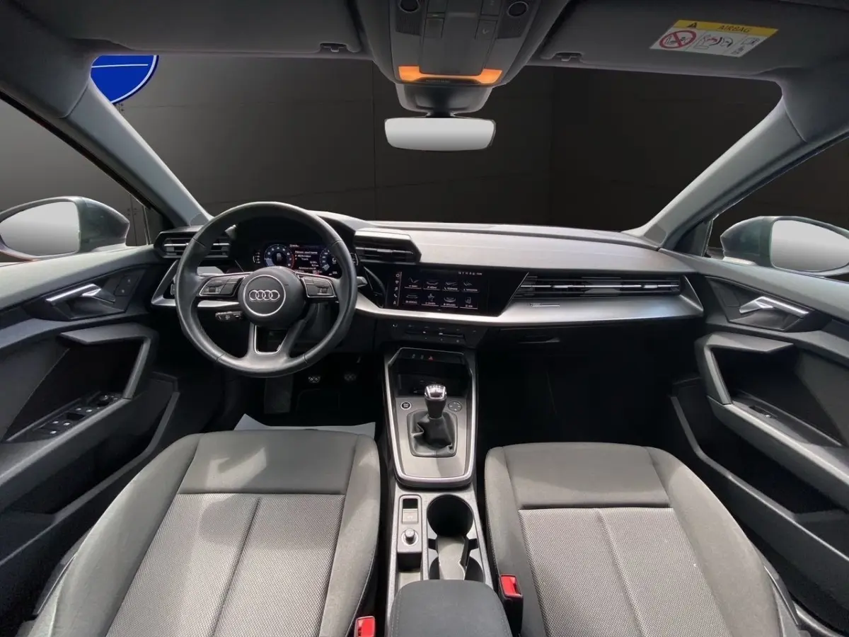 Vue intérieure frontale de l'Audi A3 30 TFSI S Line 2021 avec volant cuir, tableau de bord numérique et boîte manuelle.