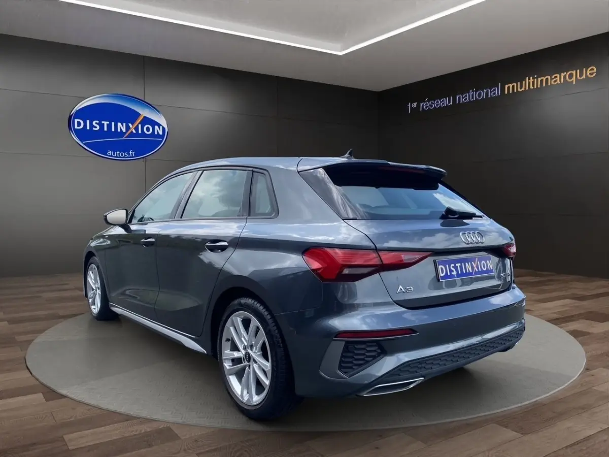 Audi A3 30 TFSI S Line gris foncé vue 3/4 arrière droit, avec jantes alliage et feux LED distinctifs.