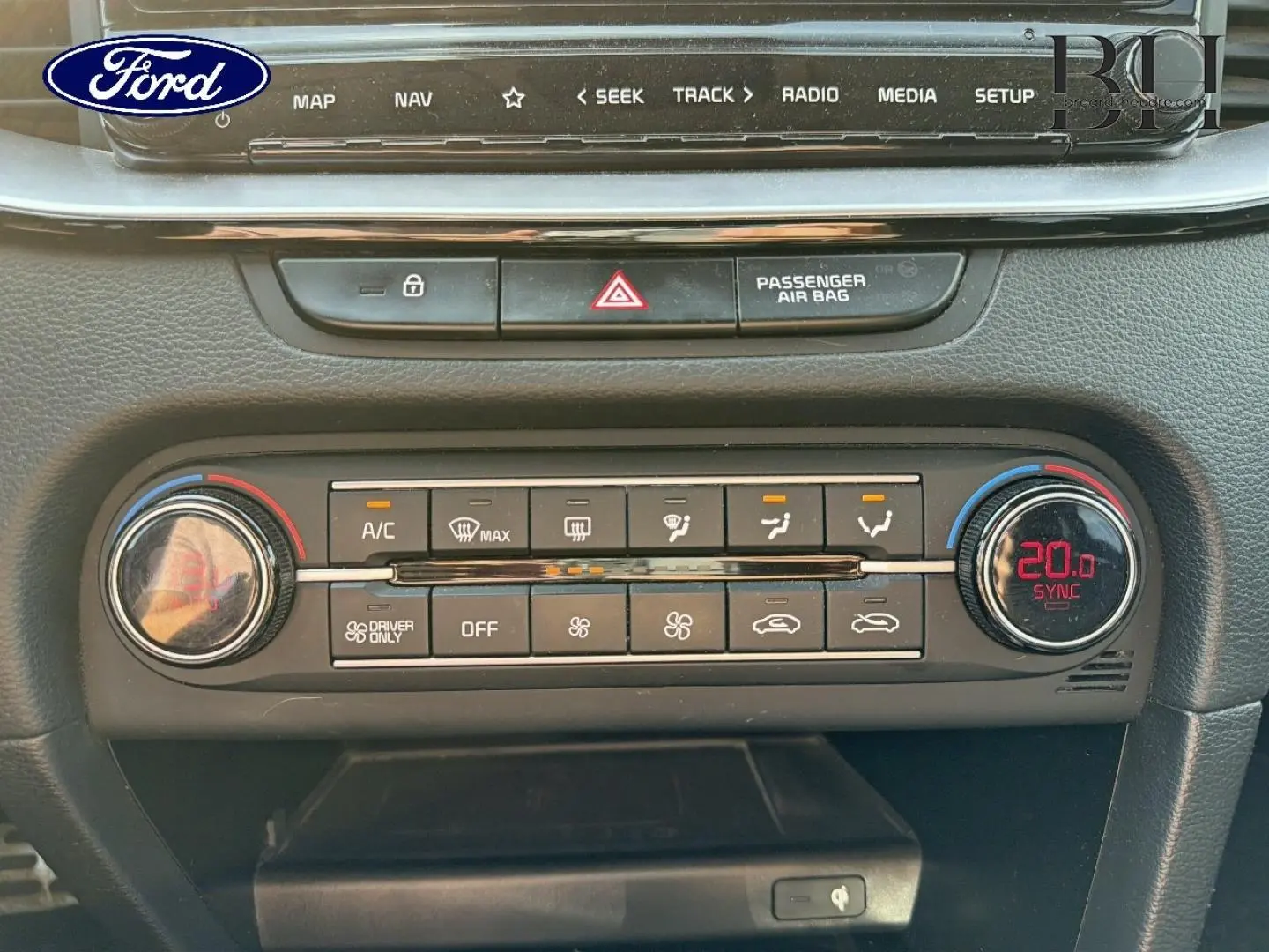 Panneau de commande de climatisation avec affichage digital rouge, boutons noirs et finition mate dans un intérieur Ford.