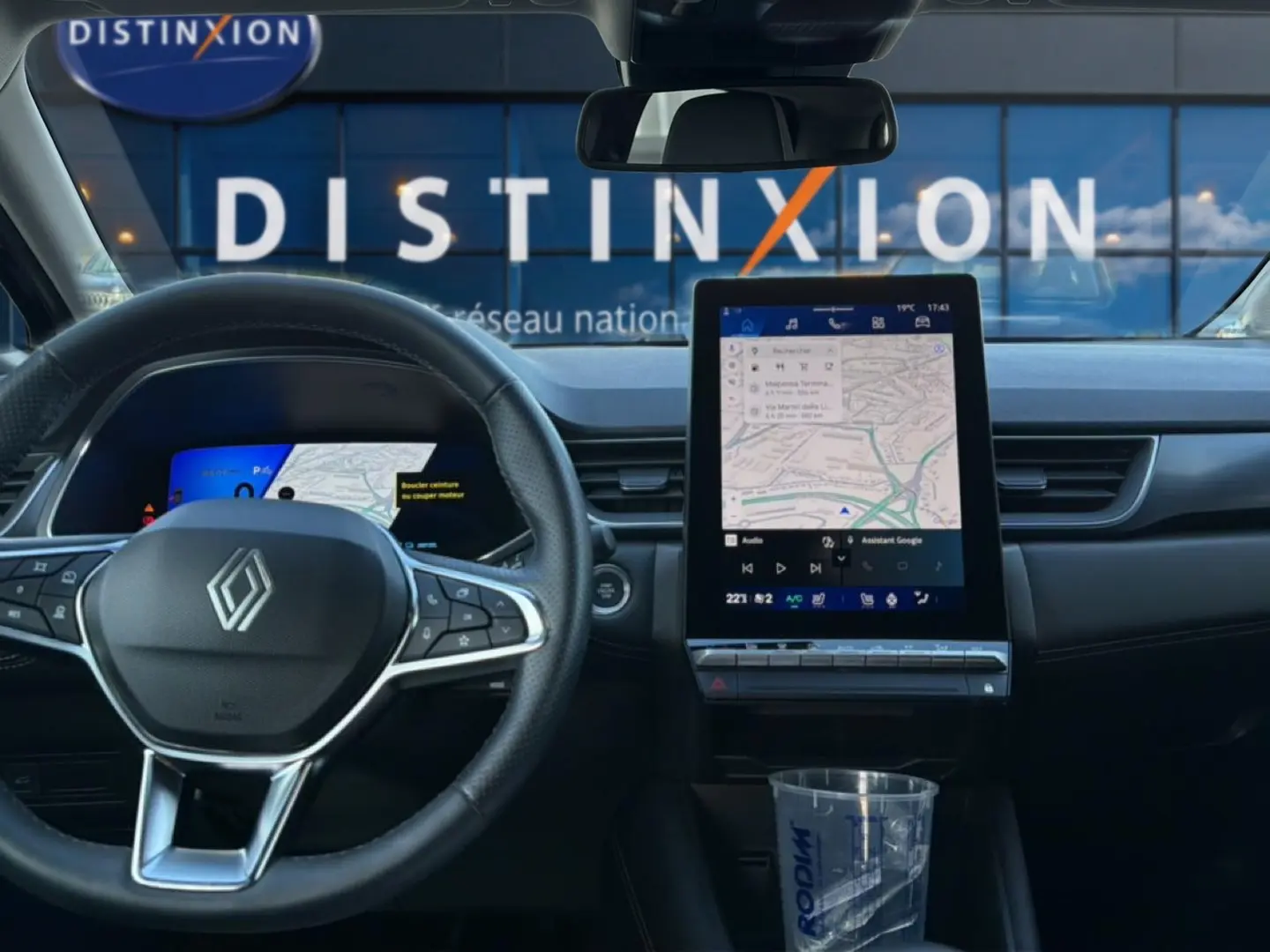 Vue intérieure frontale du tableau de bord gris du Renault Symbioz 2025 avec écran tactile vertical et volant multifonction.