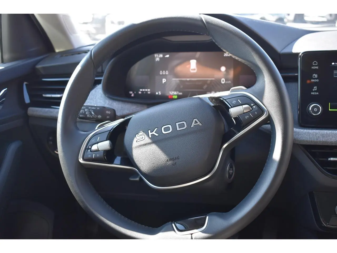 Vue rapprochée du volant cuir multifonctions SKODA SCALA 2025 avec tableau de bord numérique et inserts gris suédine.