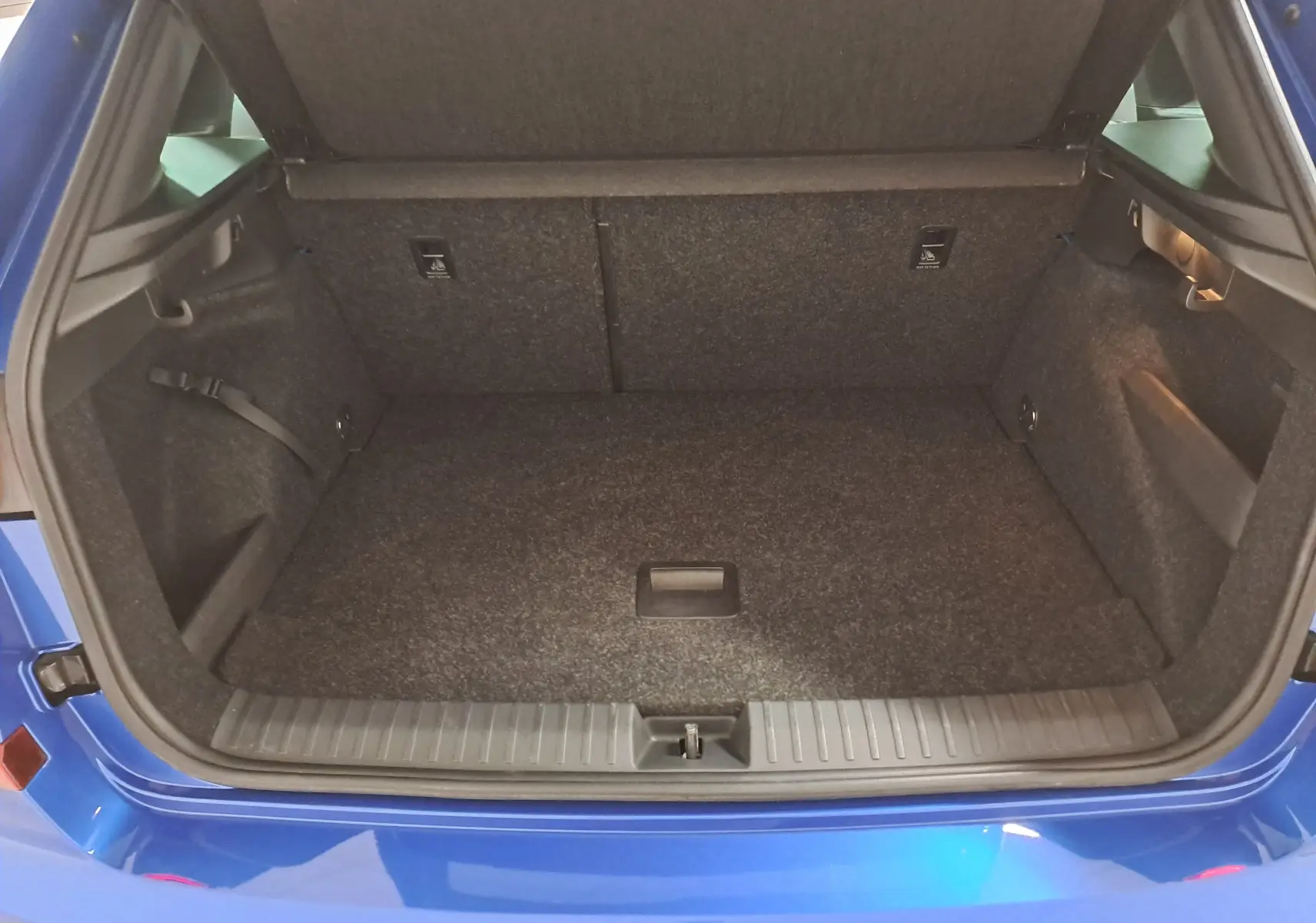 Coffre ouvert du Skoda Kamiq Bleu RS 2024, vue arrière montrant le double plancher et l’espace de chargement.