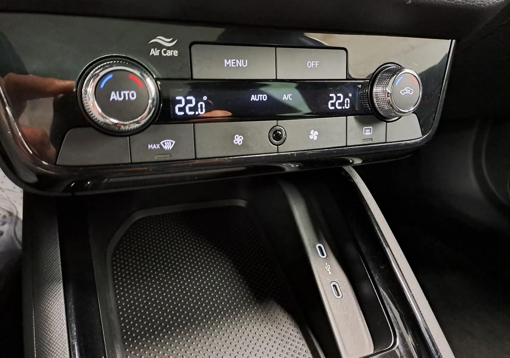 Vue rapprochée de la console centrale du Skoda Kamiq 2024, avec commandes climatisation digitale et ports USB visibles.