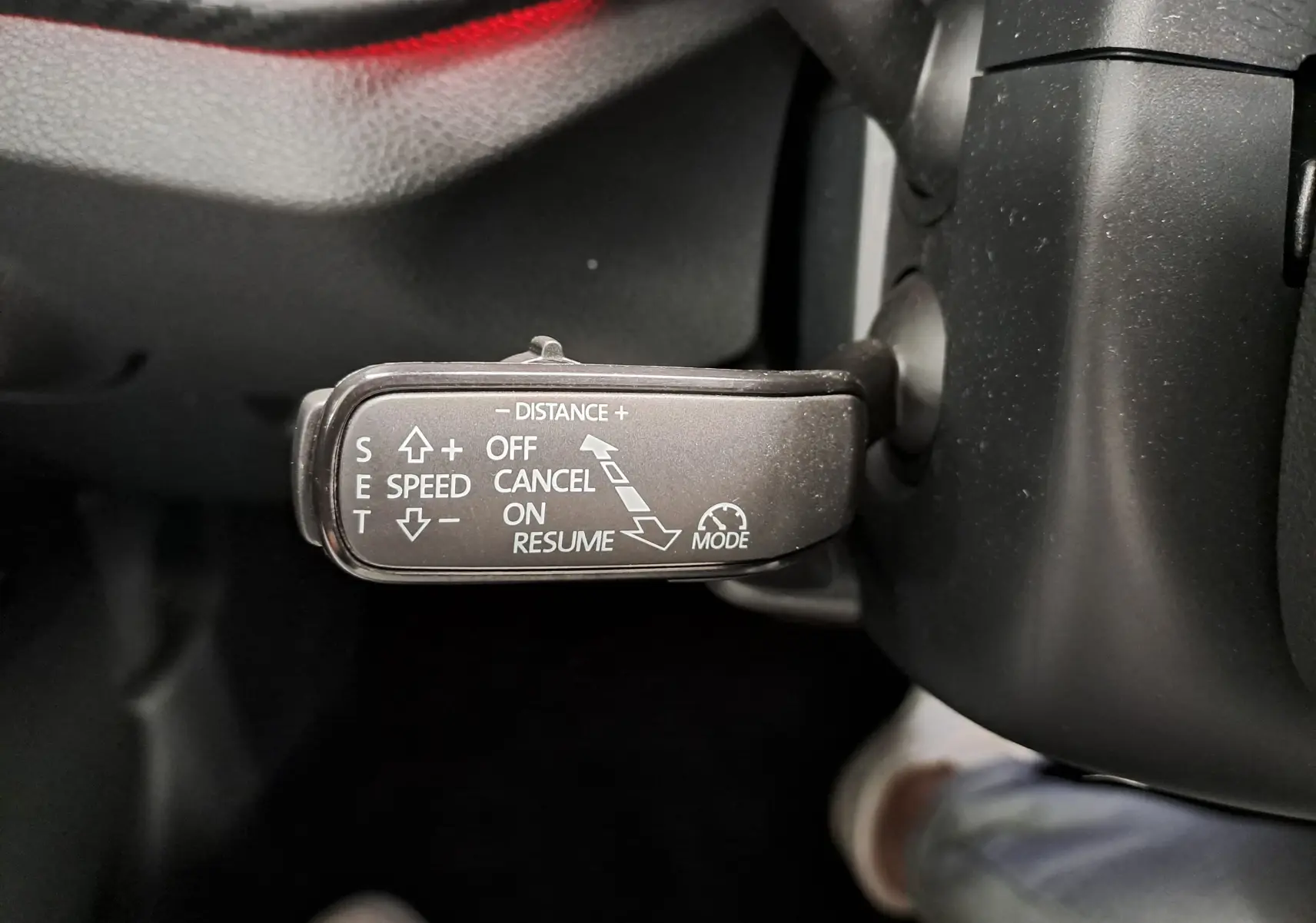 Gros plan sur le levier de commande du régulateur de vitesse dans l'habitacle noir du Skoda Kamiq Bleu RS 2024.