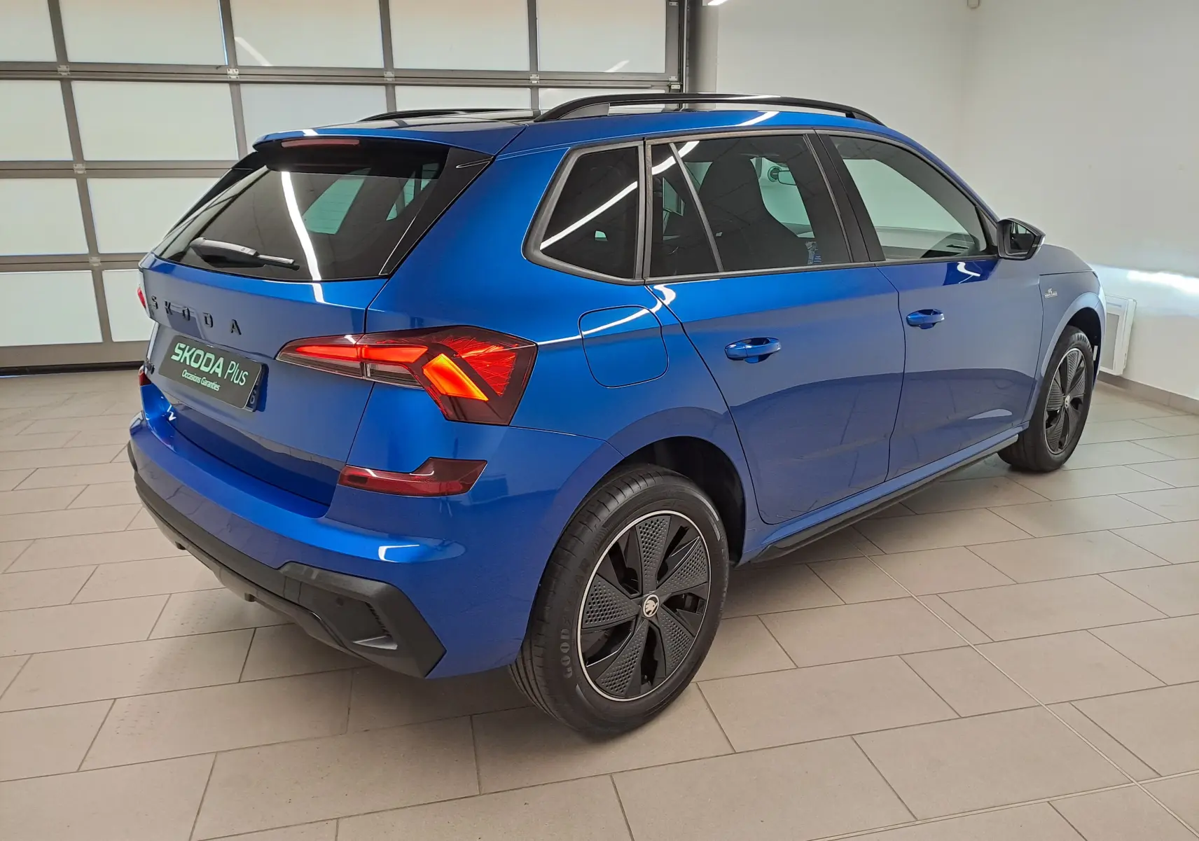 Vue 3/4 arrière droite du Skoda Kamiq 1.5 TSI 150 DSG7 Monte Carlo en bleu RS avec jantes noires distinctives.