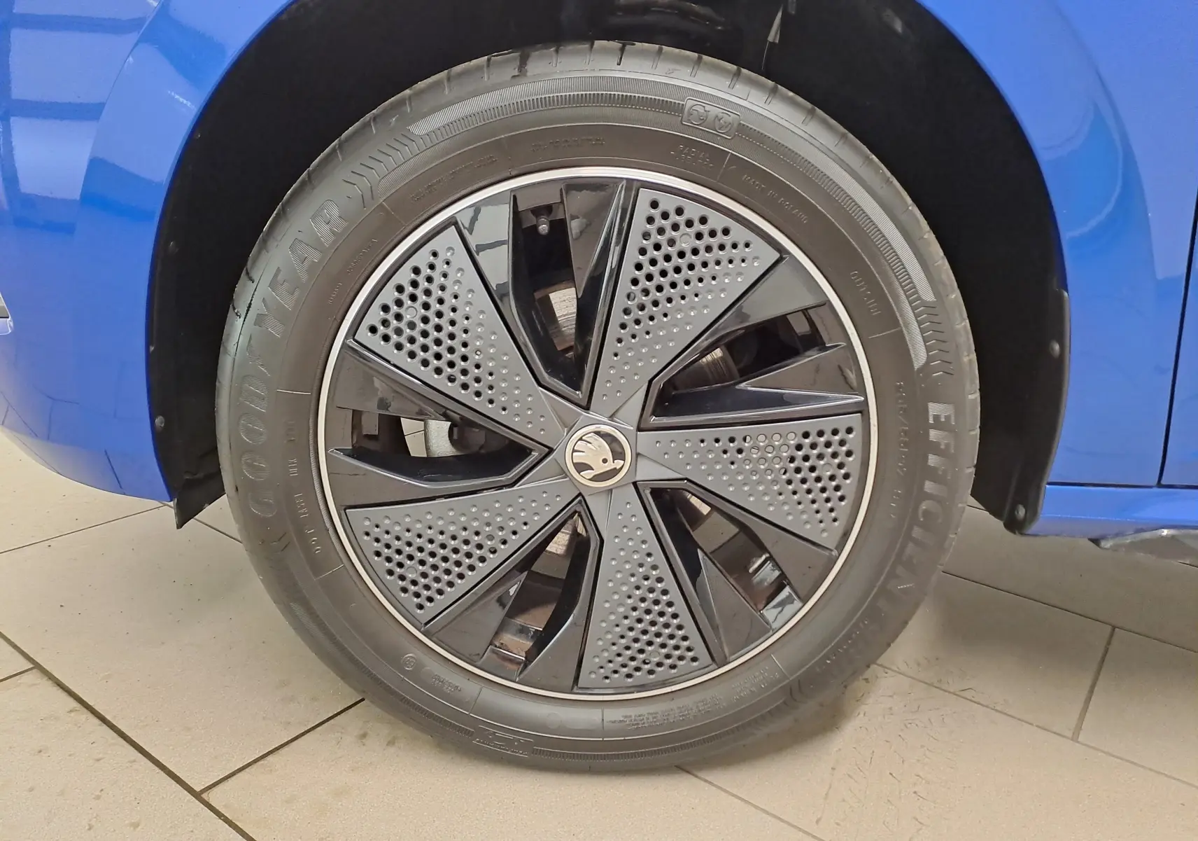 Gros plan sur la roue avant gauche bleu RS du Skoda Kamiq 2024 avec jante noire au design perforé distinctif.