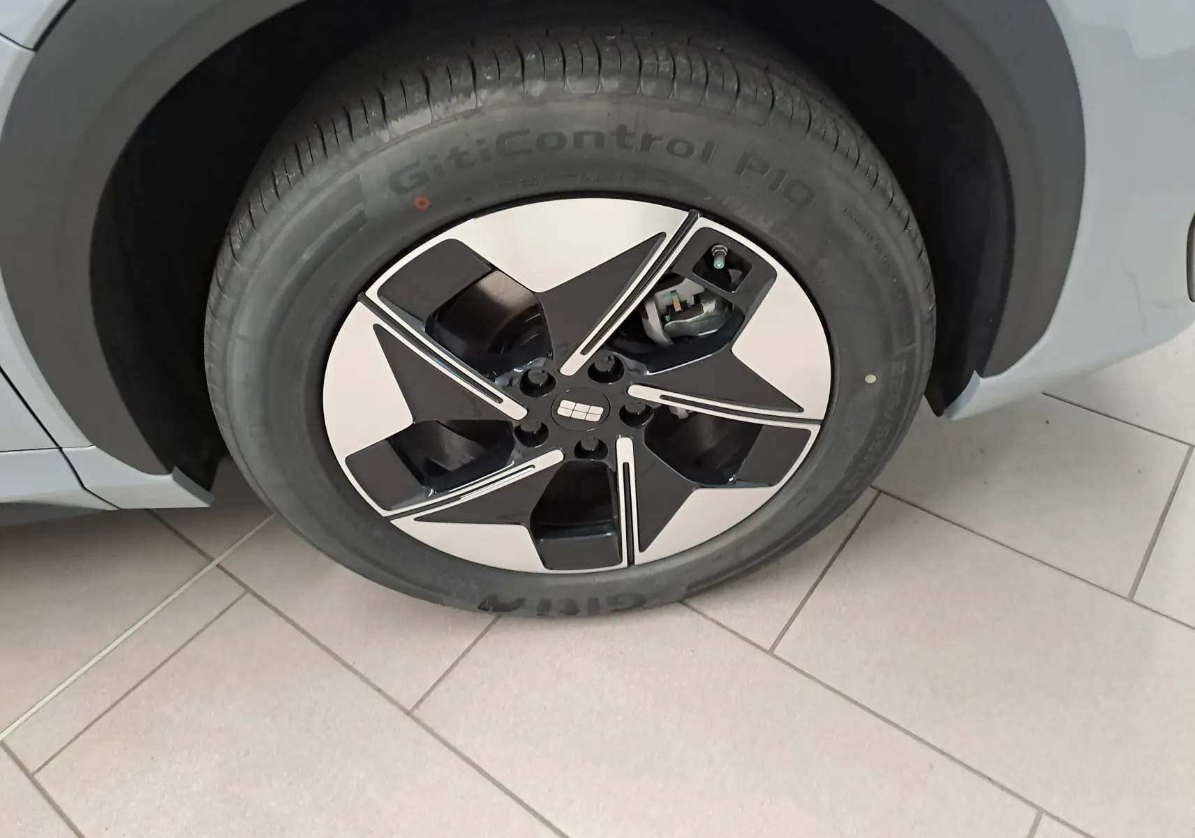 Gros plan sur la roue avant gauche du Geely E5 PRO gris Moonlight, avec jante noire et argentée au design moderne.