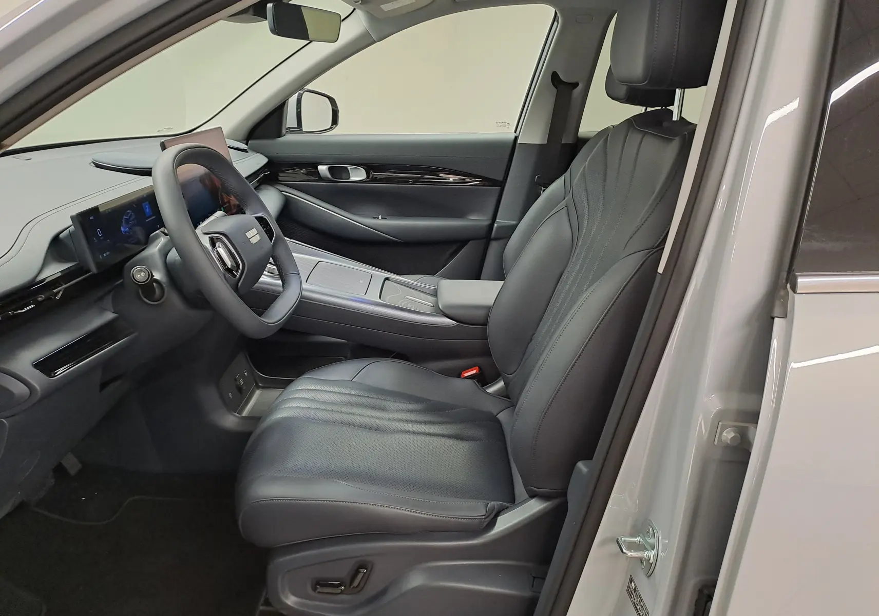 Vue intérieure côté conducteur du Geely E5 PRO 2026 gris Moonlight, mettant en valeur le siège cuir et le tableau de bord numérique.