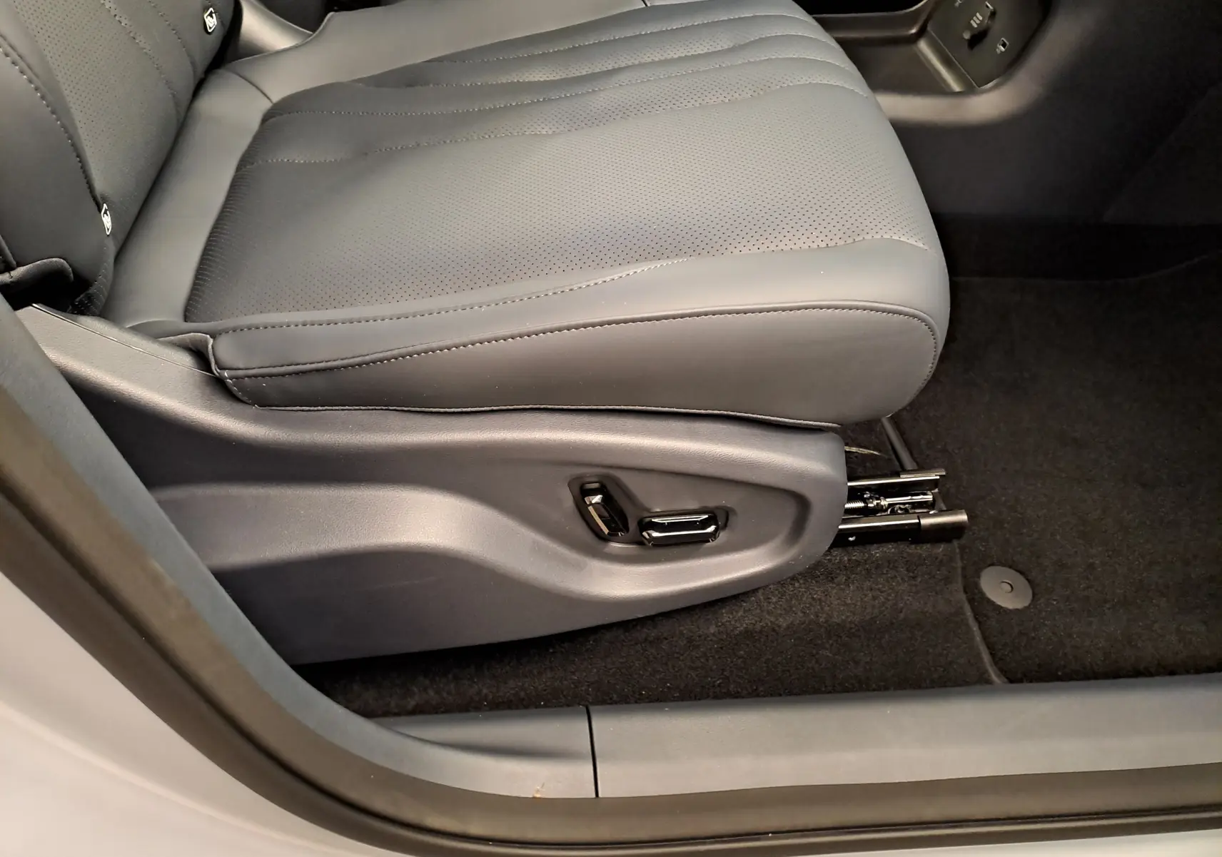 Gros plan sur le siège avant gauche gris Moonlight du Geely E5 PRO 2026 avec réglages électriques visibles.