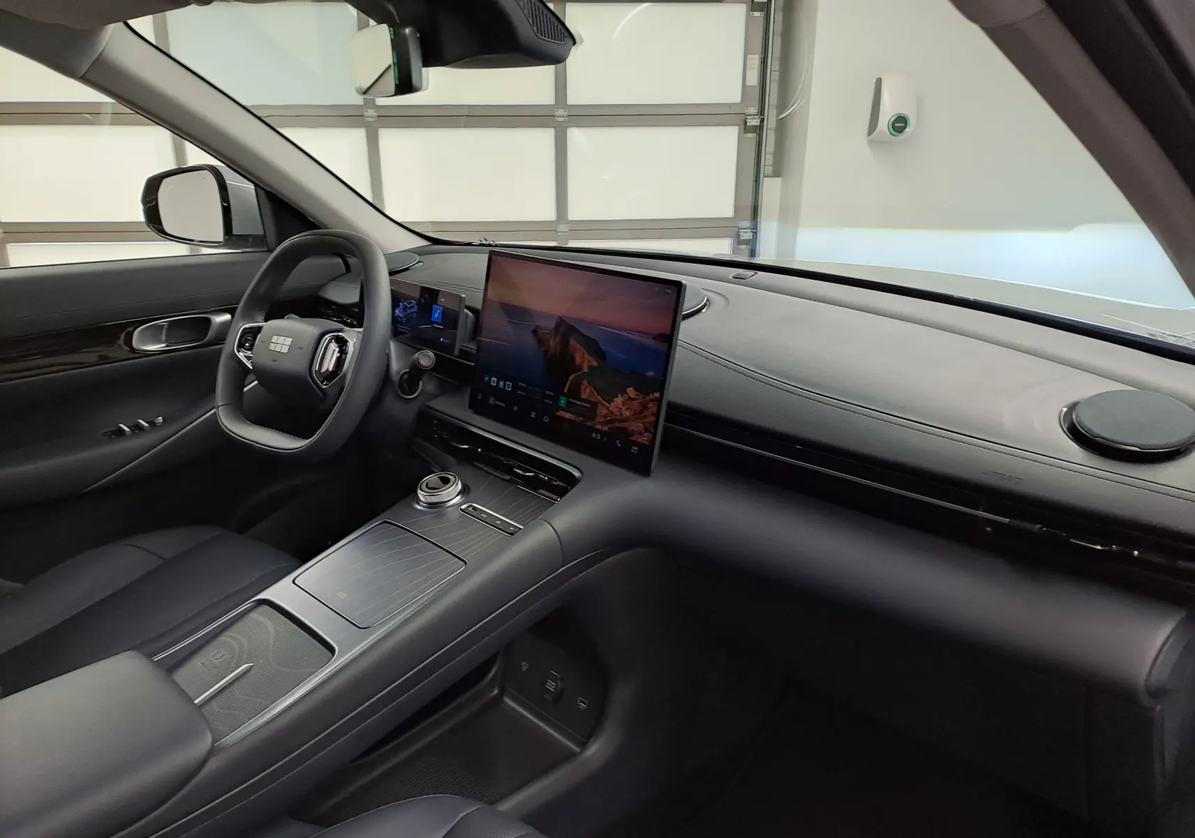Vue intérieure côté conducteur du Geely E5 PRO 218ch 60kWh 2026 gris Moonlight, avec écran tactile central et volant moderne.