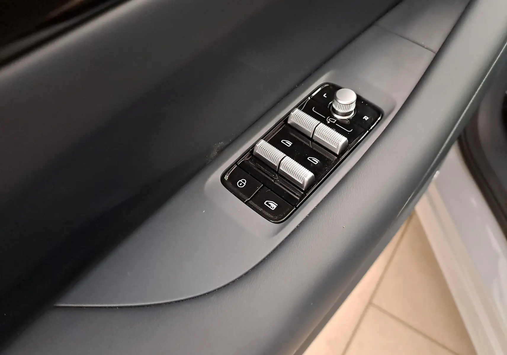 Détail des commandes de lève-vitres et réglage des rétroviseurs côté gauche du Geely E5 PRO gris Moonlight 2026.