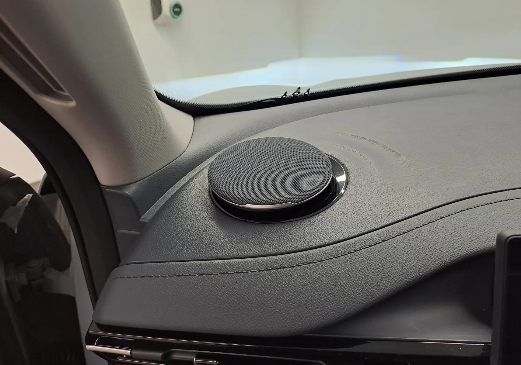 Gros plan sur l'enceinte ronde intégrée au tableau de bord gris Moonlight côté gauche du Geely E5 PRO 2026 électrique.