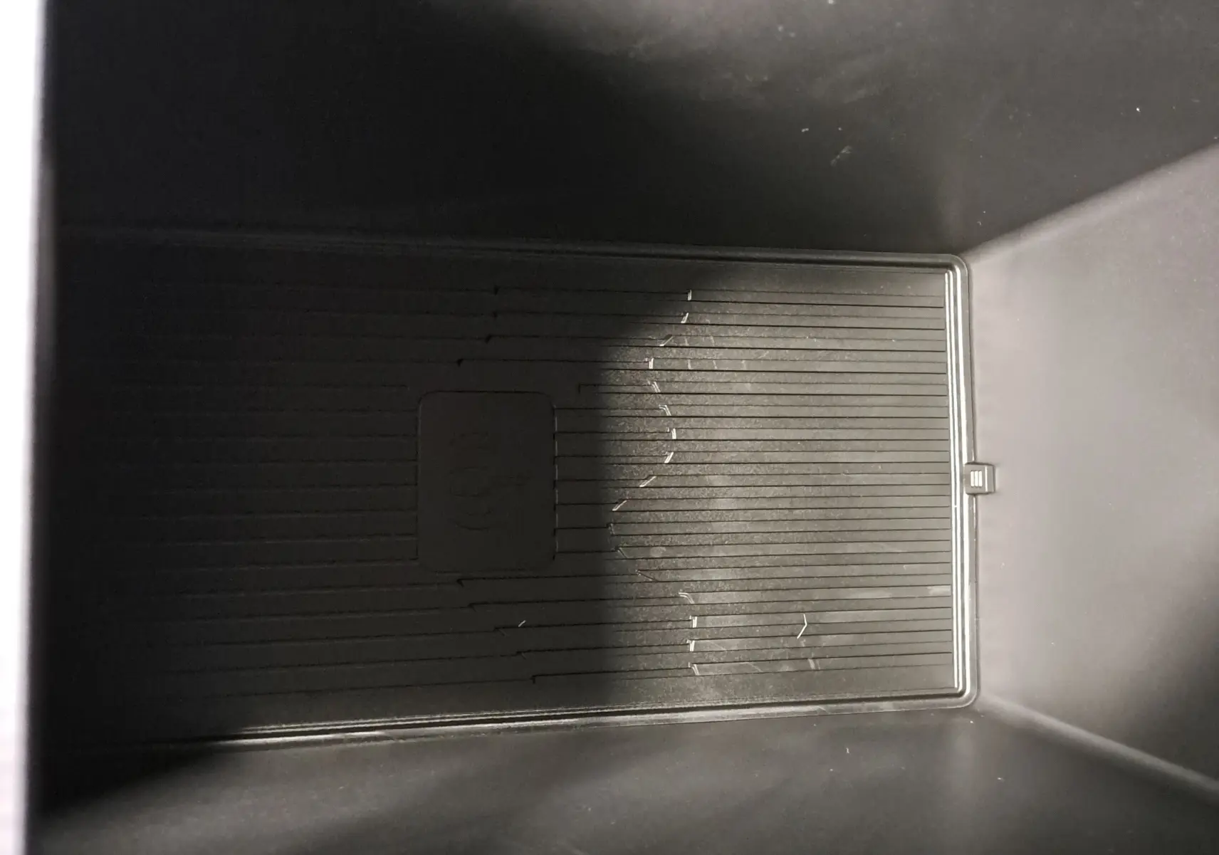 Intérieur du compartiment de rangement noir du Geely E5 PRO 218ch 60kWh, vue plongeante sans éléments distinctifs visibles.