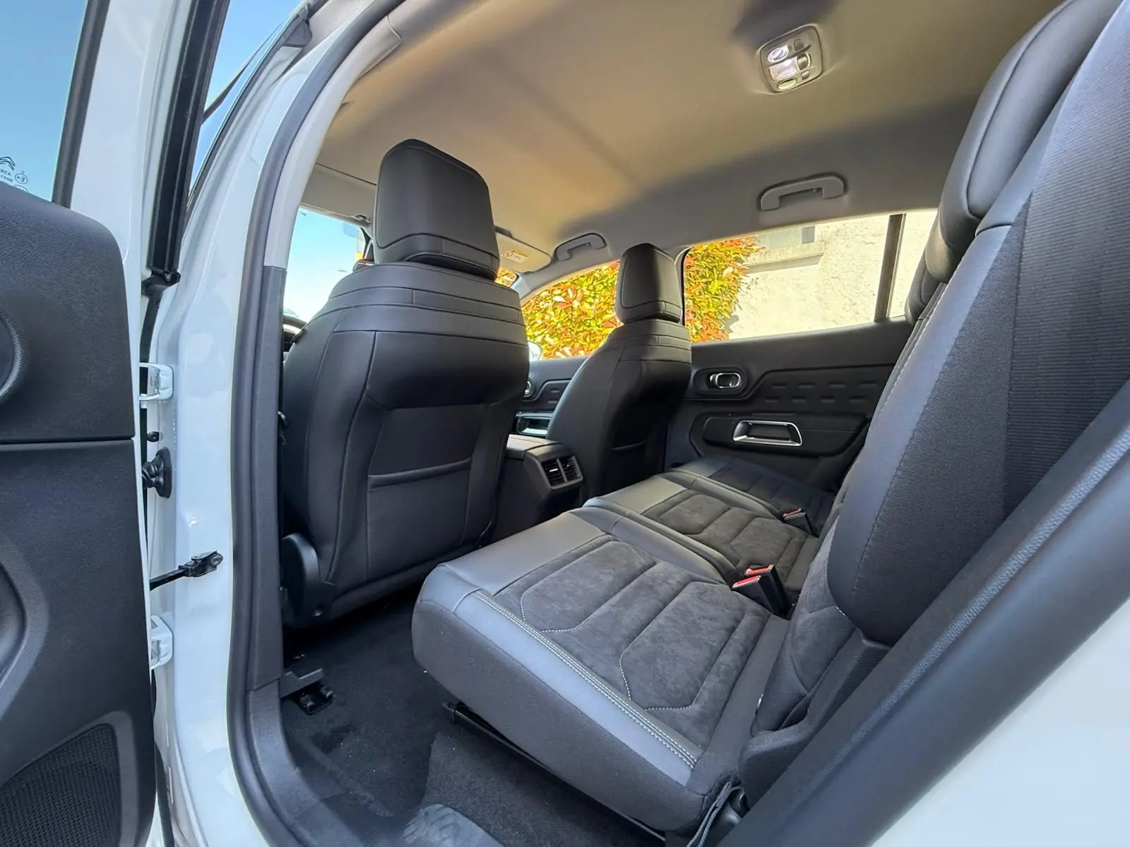 Vue intérieure côté droit arrière du Citroën C5 Aircross blanc banquise, sièges arrière en tissu et cuir noir.