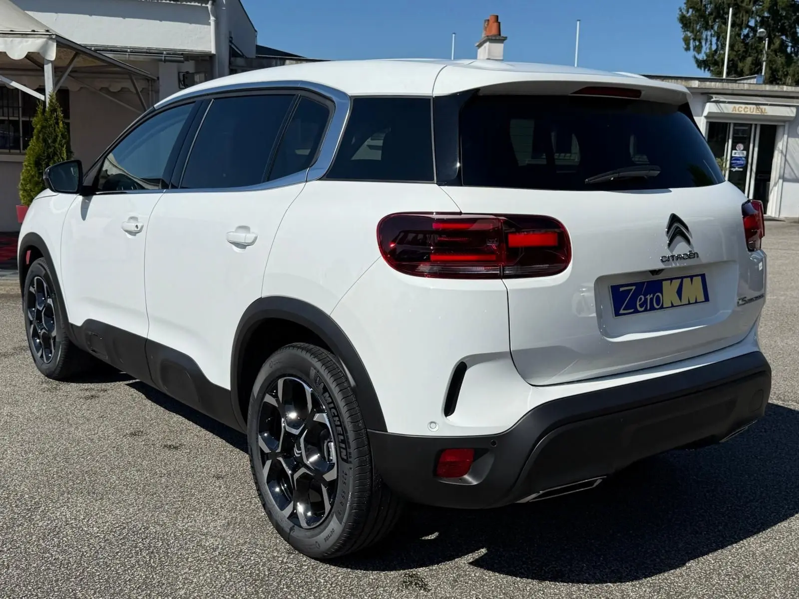 Vue 3/4 arrière droite d'un Citroën C5 Aircross blanc banquise avec jantes bi-ton et détails noirs contrastants.
