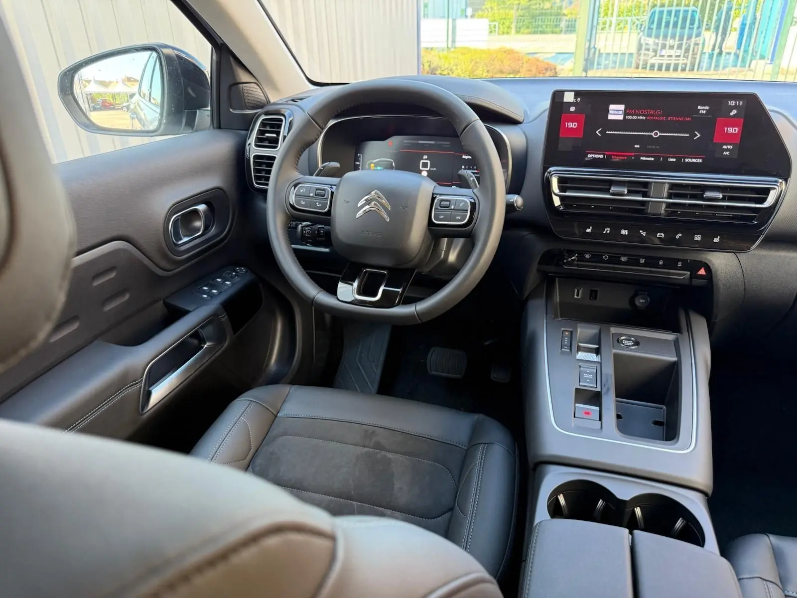 Vue intérieure du poste de conduite du Citroën C5 Aircross blanc banquise, avec tableau de bord numérique et écran tactile central.