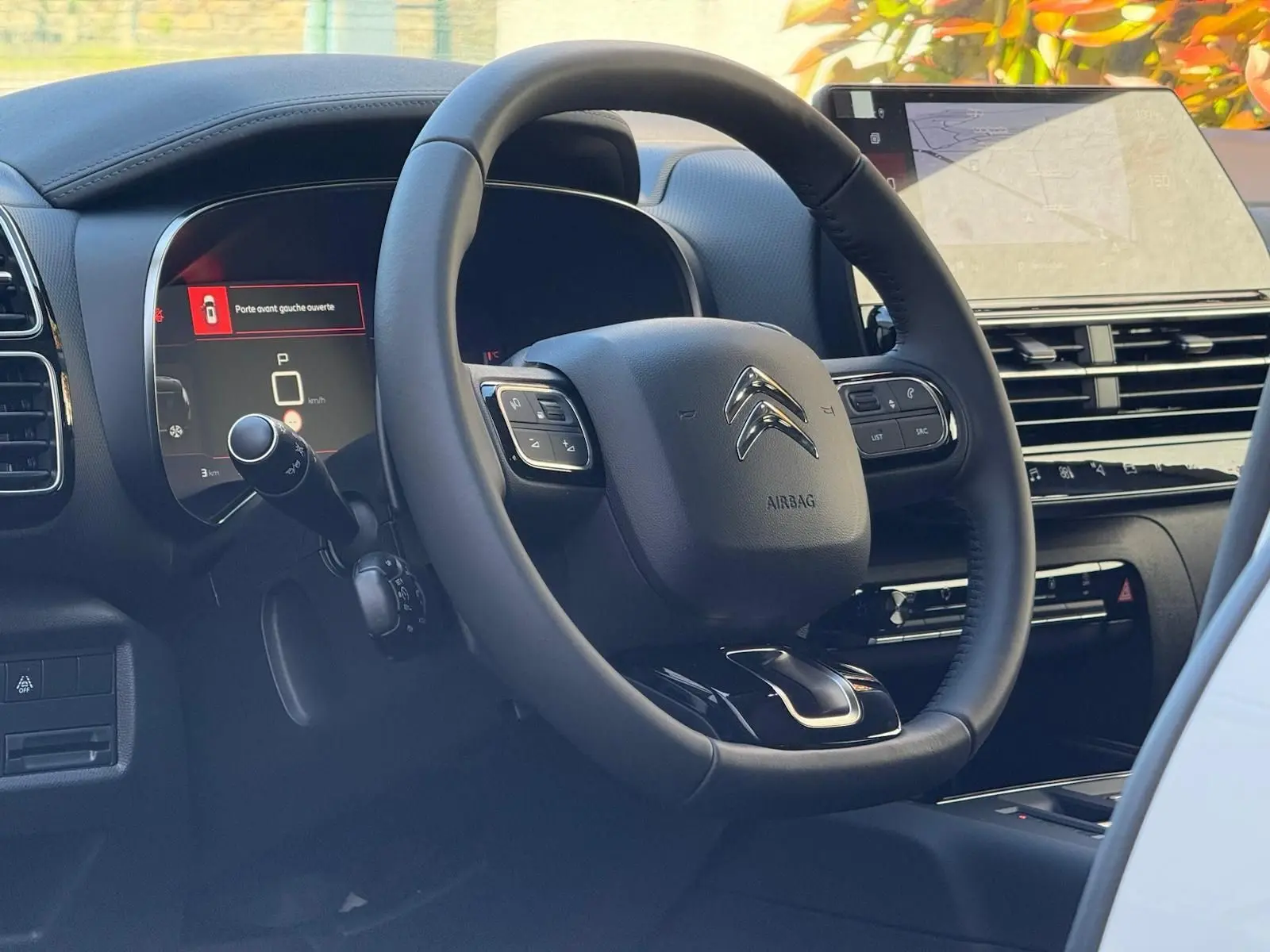 Intérieur du Citroën C5 Aircross 2024, vue du volant cuir noir et tableau de bord numérique avec écran tactile.