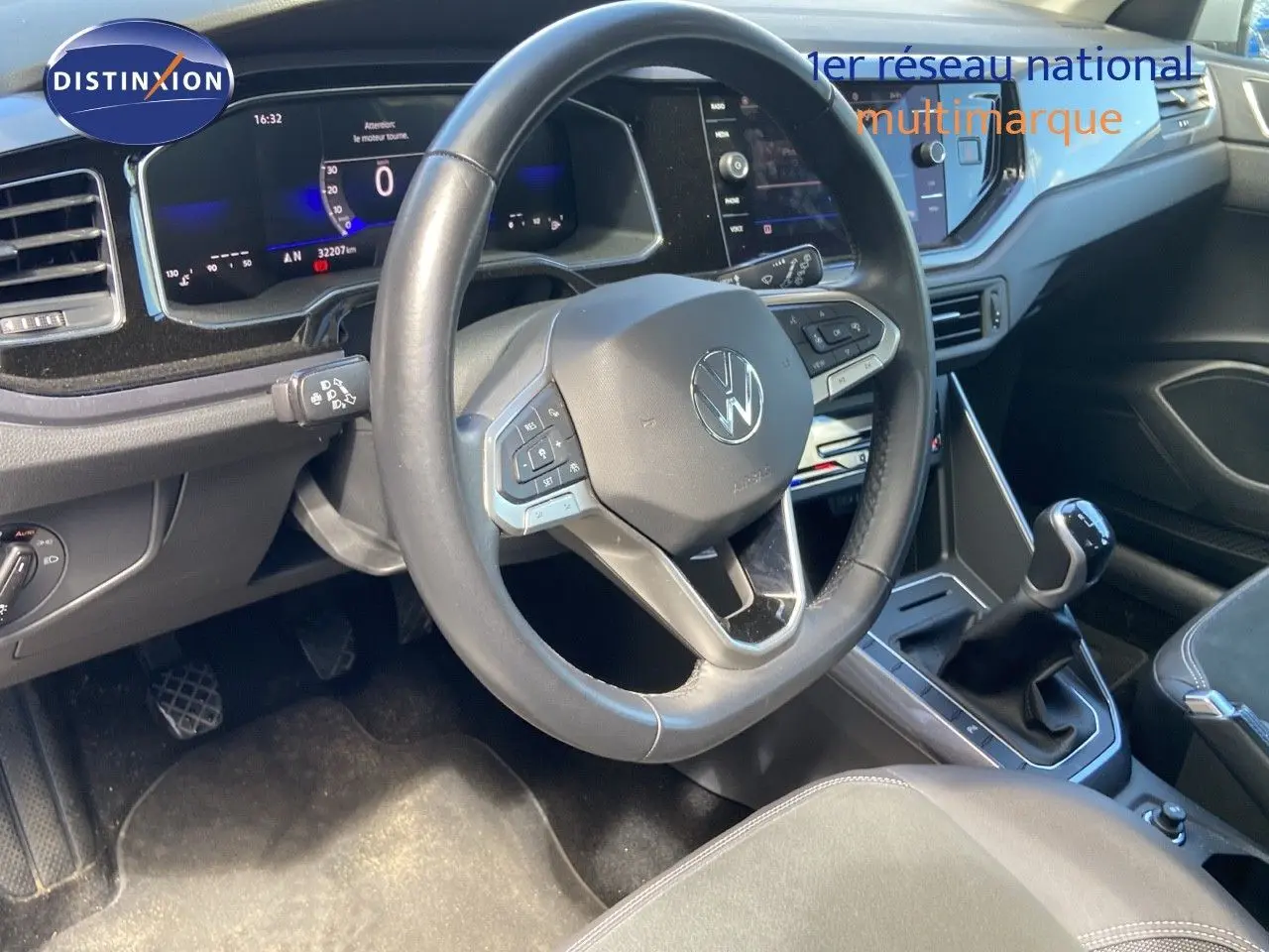 Intérieur de Volkswagen Polo 1.0 TSI 2023 montrant le volant, tableau de bord numérique et levier de vitesse manuel.