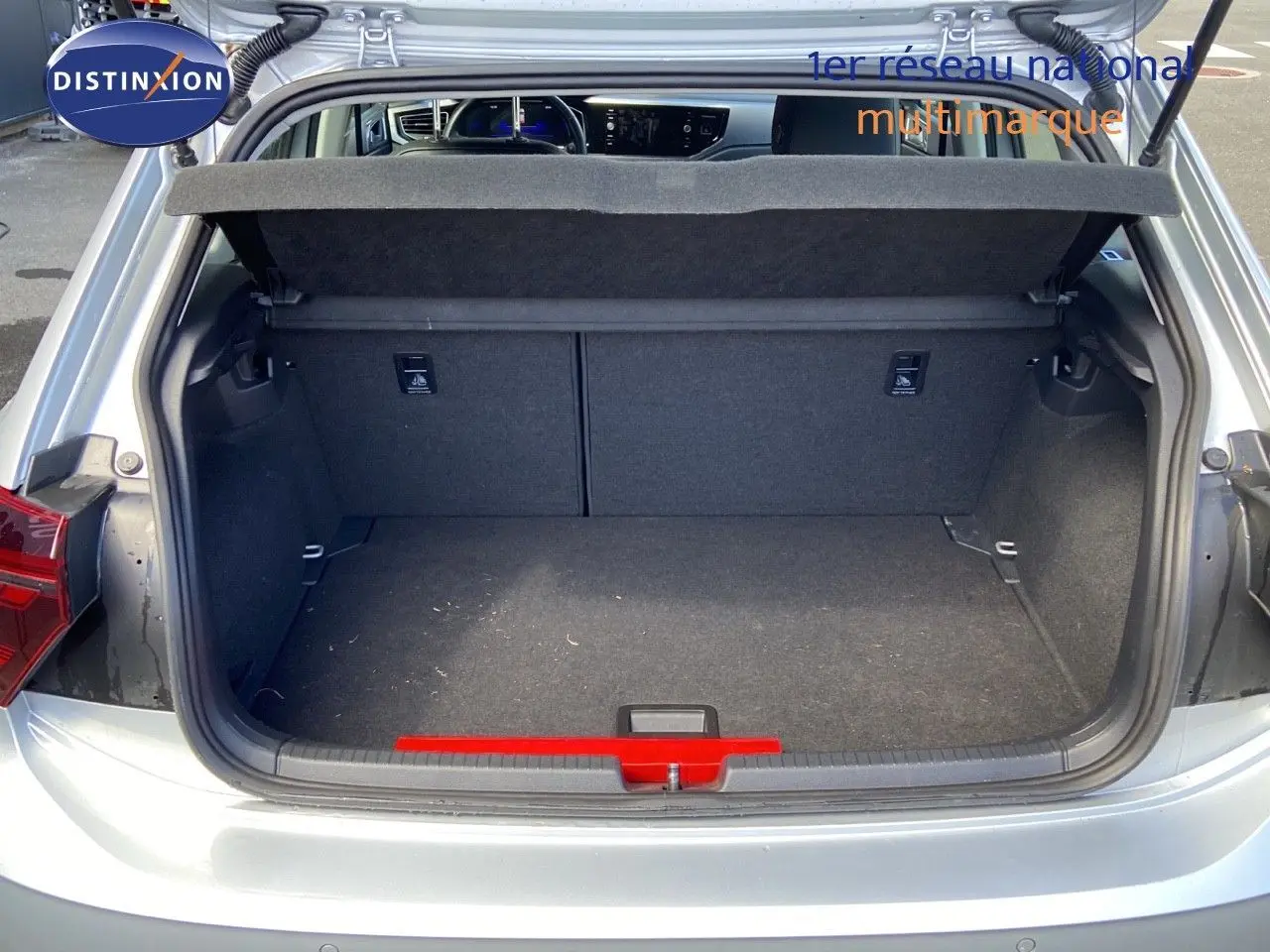 Coffre ouvert vu de l'arrière d'une Volkswagen Polo 2023 reflet d'argent métal, montrant l'espace de chargement vide.