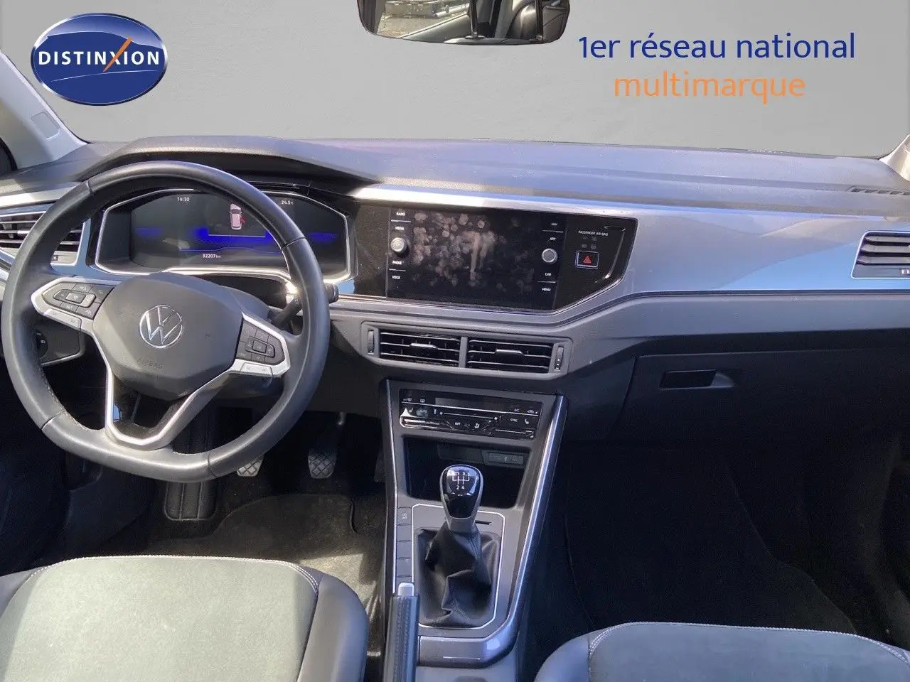 Vue intérieure de face du tableau de bord et levier de vitesse manuel d'une Volkswagen Polo 2023 finition Style en reflet d'argent métal.