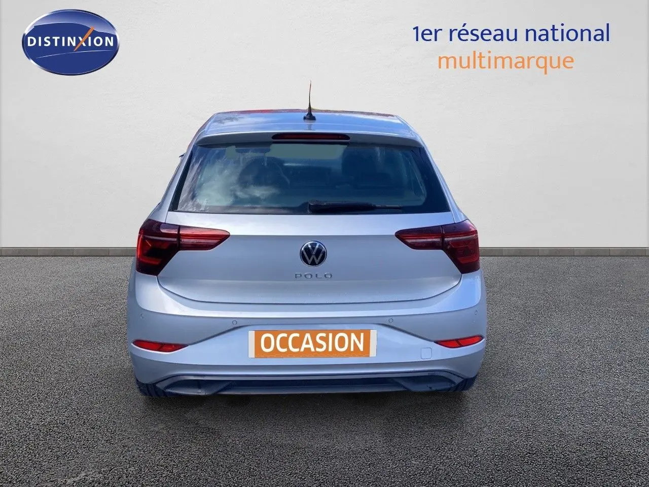 Vue arrière d'une Volkswagen Polo 2023 couleur reflet d'argent métal, avec plaque d'immatriculation orange "OCCASION".