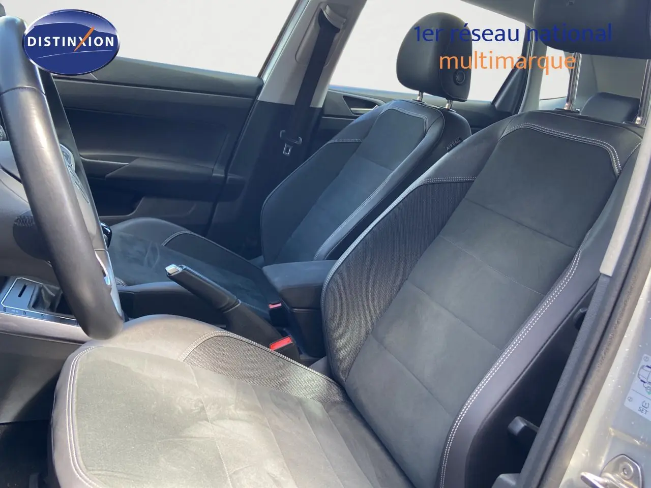 Vue intérieure côté conducteur de la Volkswagen Polo 1.0 TSI 95ch Style 2023 avec sièges noirs en cuir et alcantara.