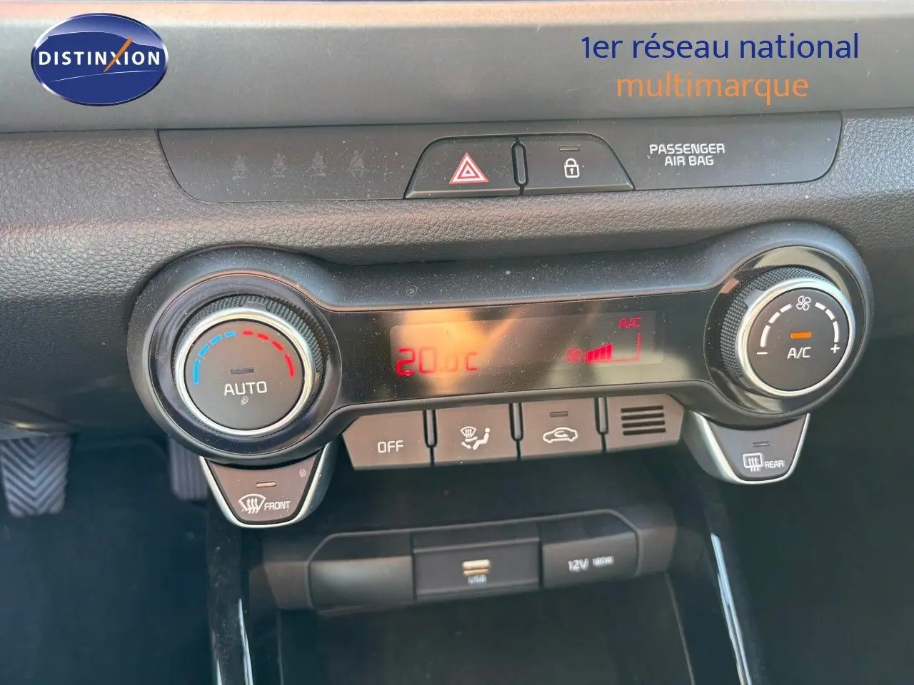 Tableau de bord du Kia Stonic 2024 montrant la console de climatisation automatique avec affichage digital rouge.