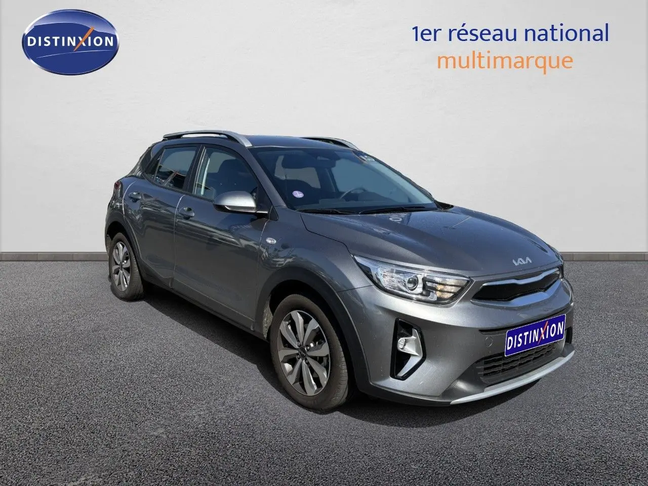 KIA Stonic gris météore en 3/4 avant droit, mettant en valeur ses optiques LED et ses jantes bi-ton.