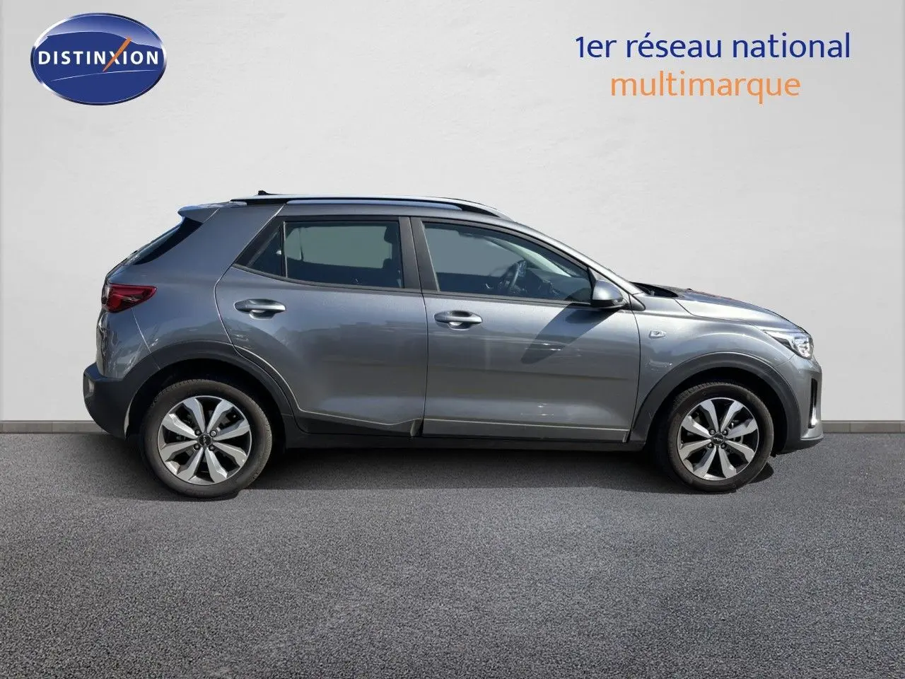 Profil côté gauche du KIA STONIC 2024 gris météore avec jantes bi-ton et toit noir contrasté.