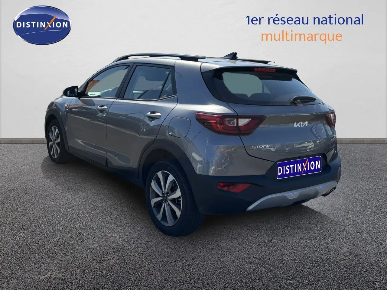 KIA STONIC gris météore vu en 3/4 arrière droit, avec jantes bi-ton et toit noir contrastant.