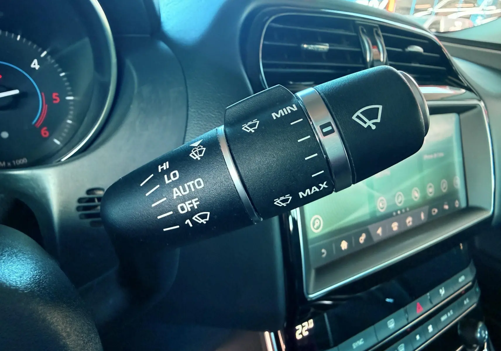 Gros plan sur la commande d'essuie-glace noire dans l'habitacle d'une Jaguar XE 2.0D 180CH Prestige de 2019.