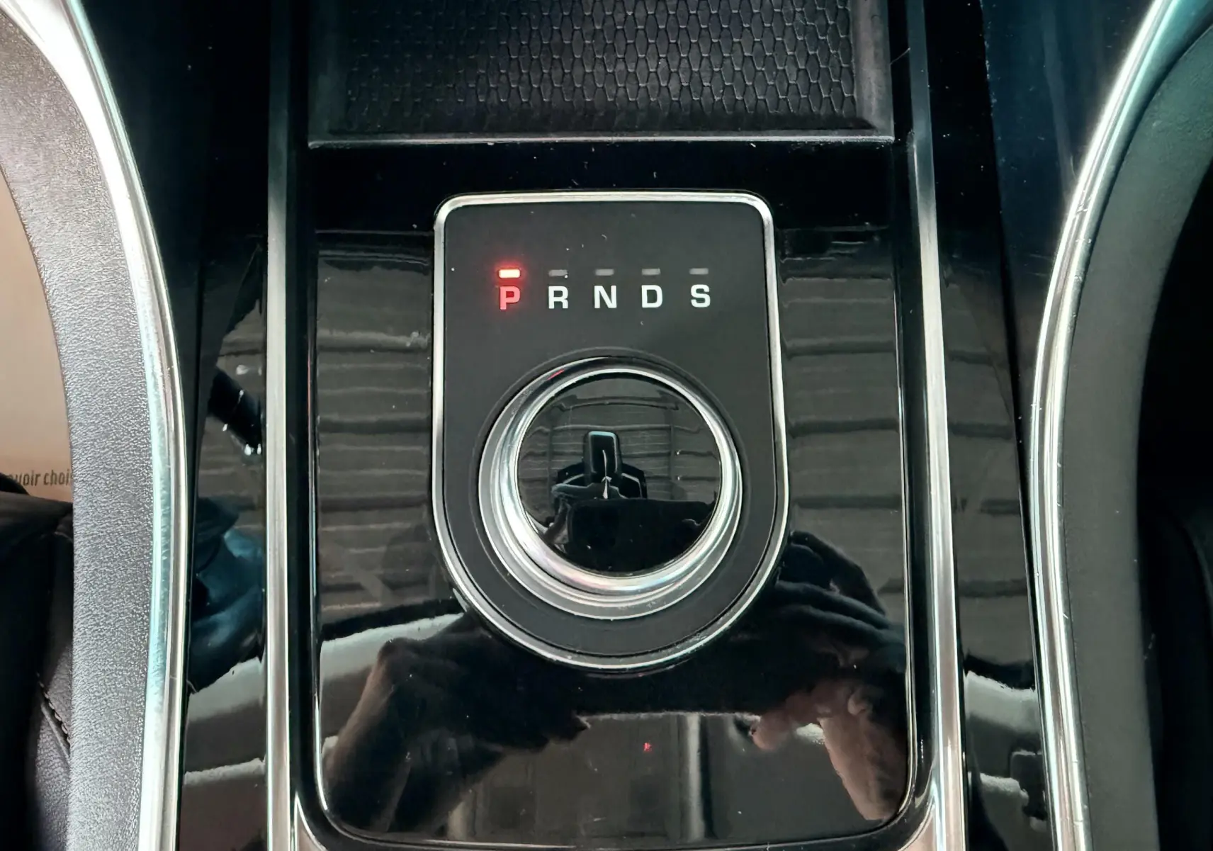Sélecteur rotatif de boîte automatique sur console noire brillante d'une Jaguar XE 2019.