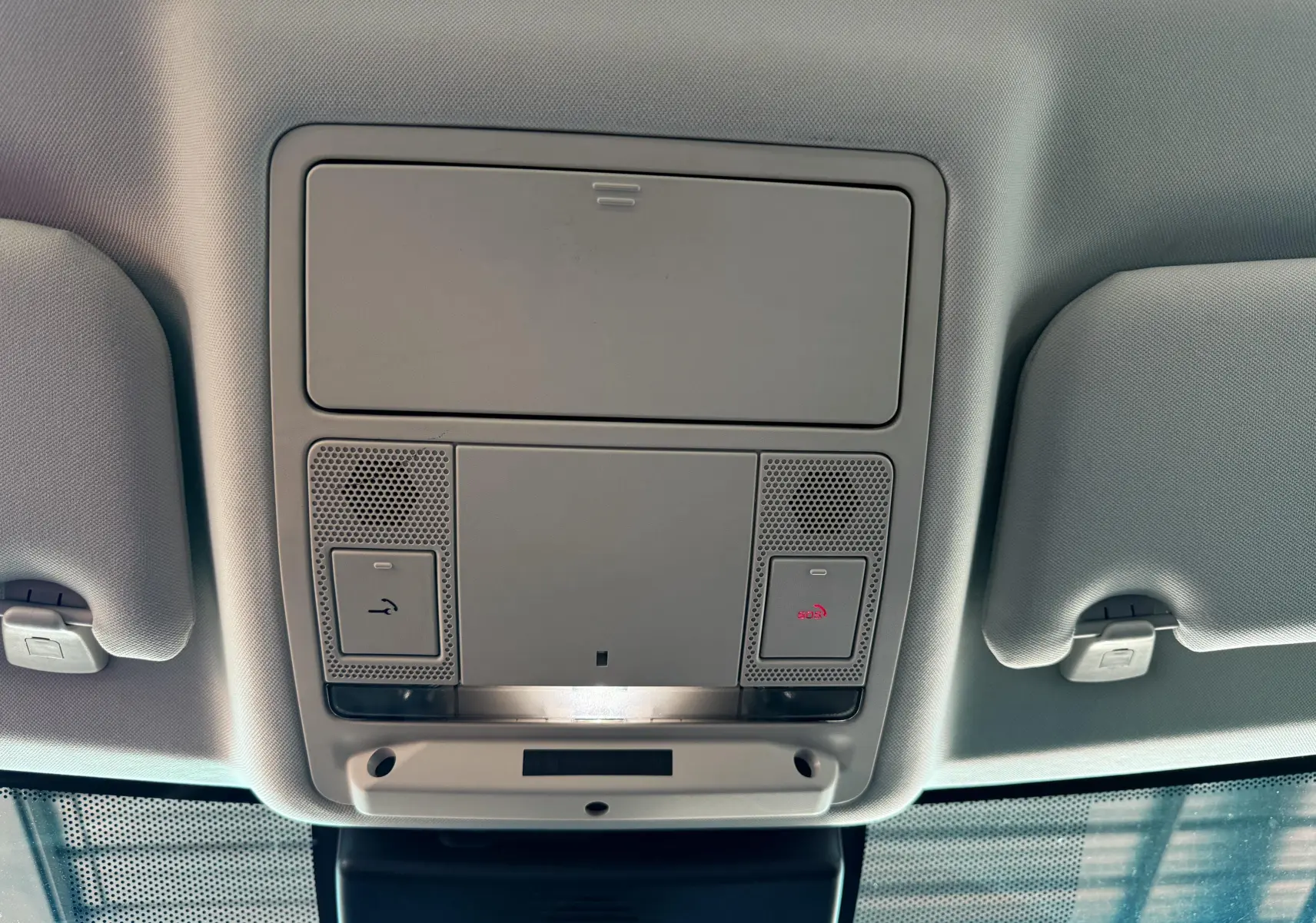 Plafonnier intérieur gris clair avec commandes d'appel et éclairage dans une Jaguar XE noire de 2019.