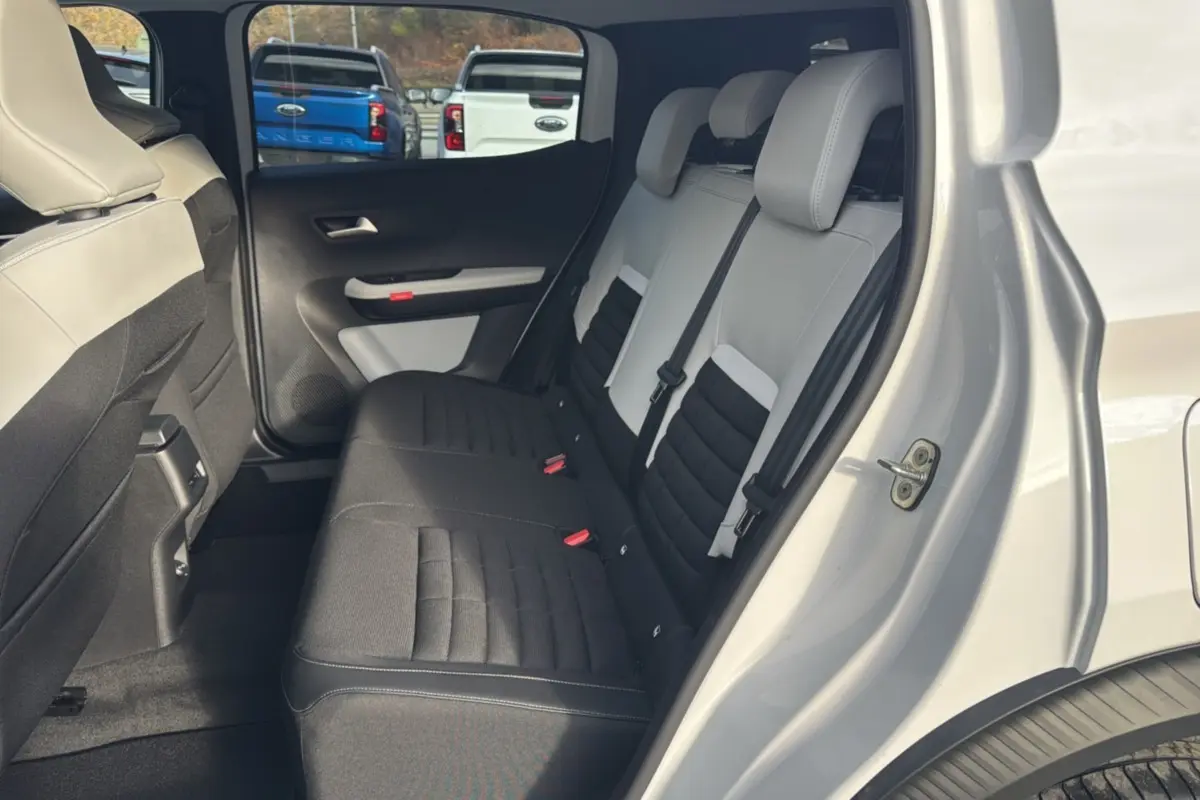 Vue côté droit de l'intérieur arrière du Citroën C3 Aircross blanc banquise, sièges tissu bicolores noirs et gris.