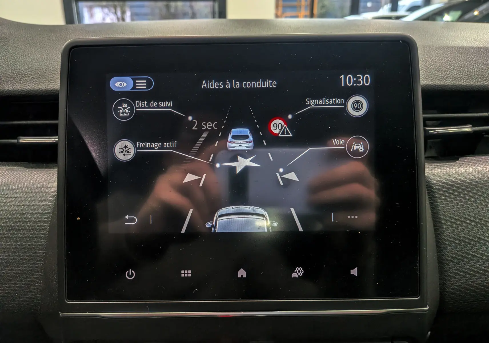 Écran tactile intérieur de la Renault Clio V blanc Glacier montrant les aides à la conduite et la signalisation à 10h30.