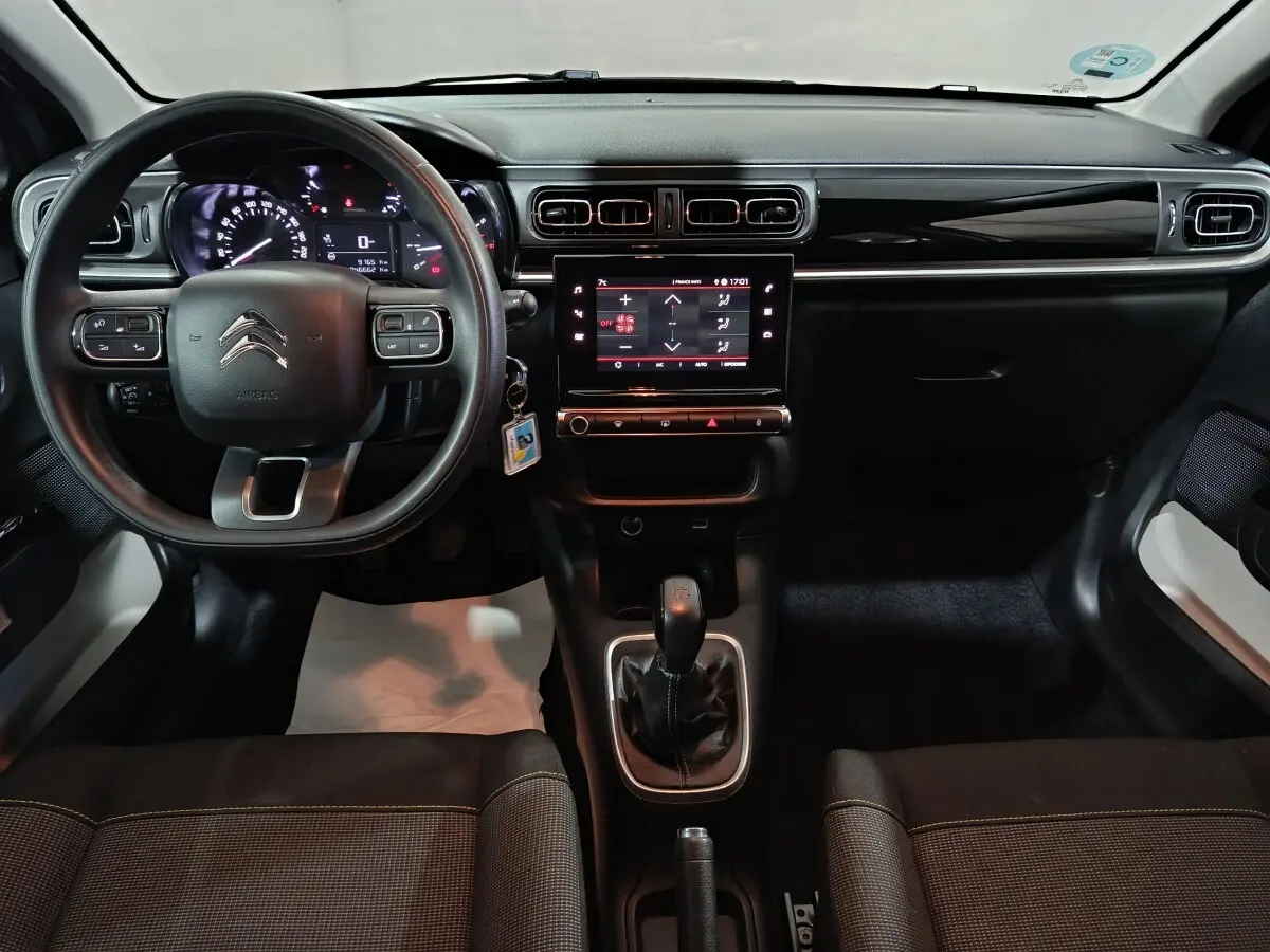 Vue intérieure avant de la Citroën C3 PureTech 83 BVM MAX 2024, tableau de bord noir avec écran tactile central et volant multifonctions.