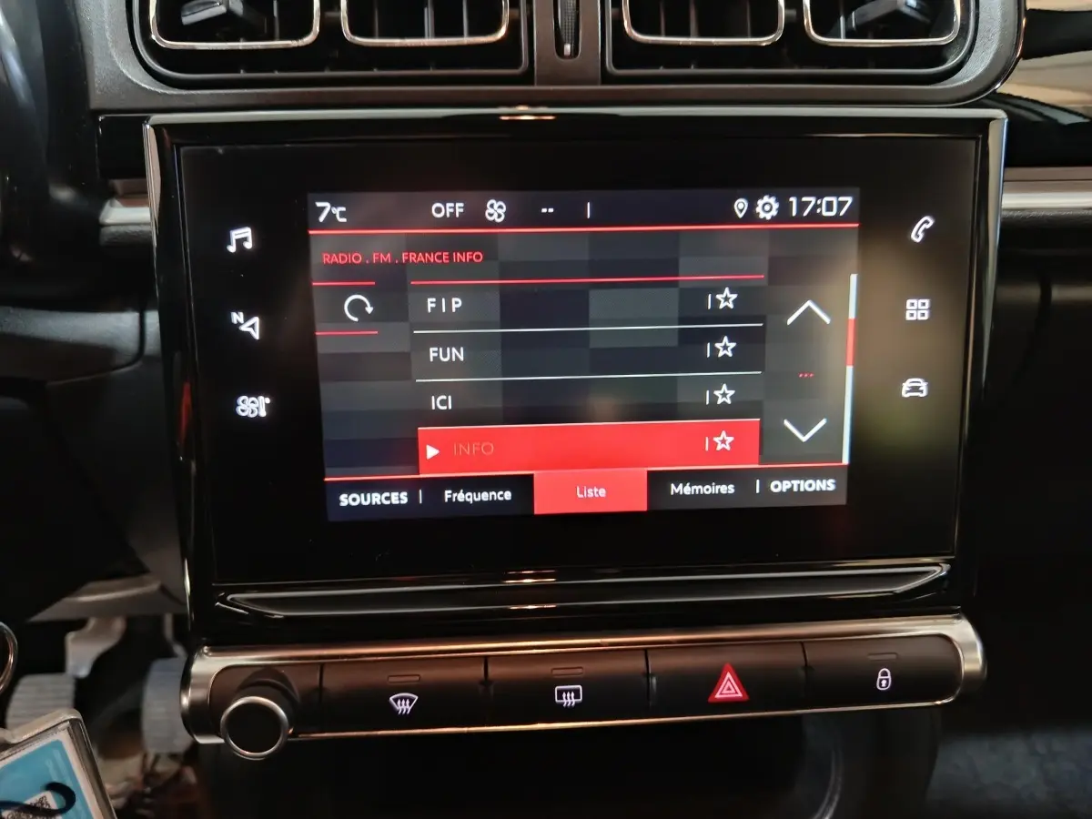 Écran tactile central allumé avec menu radio, tableau de bord noir de la Citroën C3 gris foncé 2024.