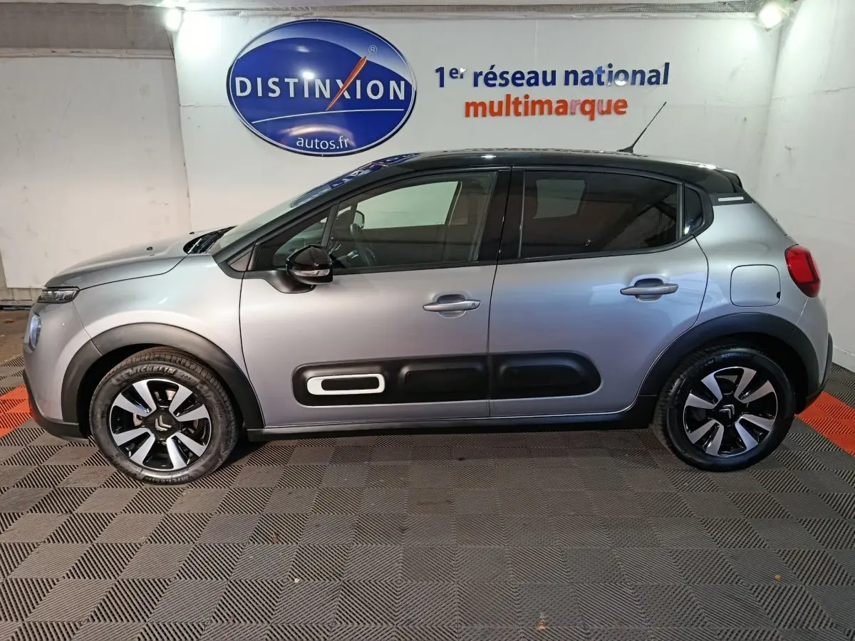 Vue latérale gauche d'une Citroën C3 gris foncé 2024 avec toit noir et protections latérales distinctives.