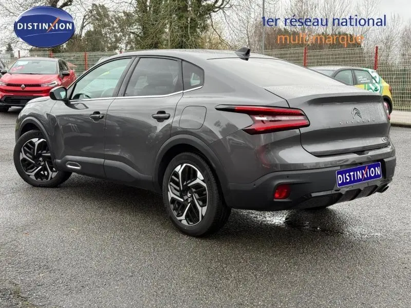 Vue 3/4 arrière droite d'une Citroën C4 X gris 2024, avec feux arrière LED et jantes alliage distinctives.