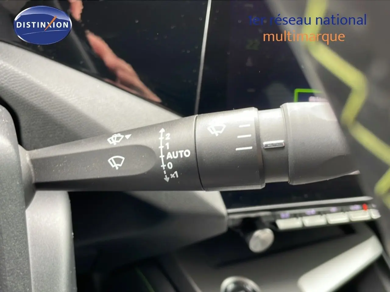 Gros plan sur la commande d’essuie-glace à gauche du volant dans l’habitacle d’une Peugeot 408 noire.