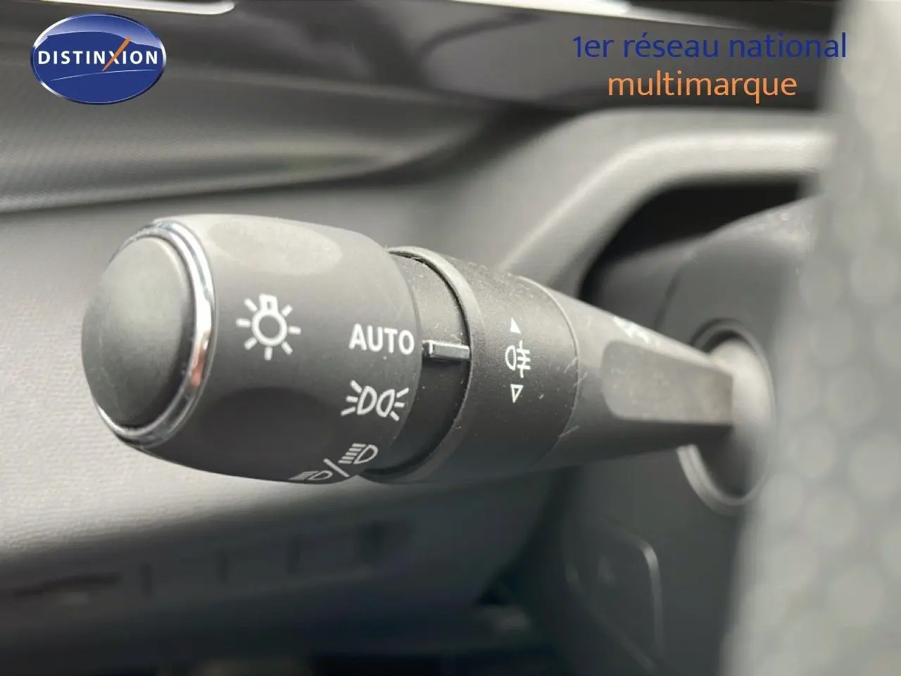 Gros plan sur la commande d’éclairage côté gauche du volant d’une Peugeot 408 Hybrid 2024 noir métal.