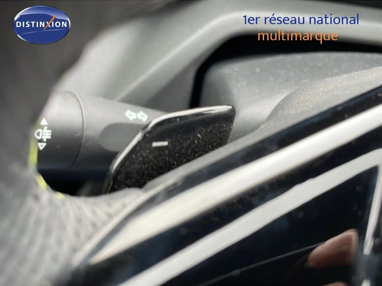 Gros plan sur la commande de clignotant et palette de frein moteur dans l’habitacle d’une Peugeot 408 noir métal 2024.
