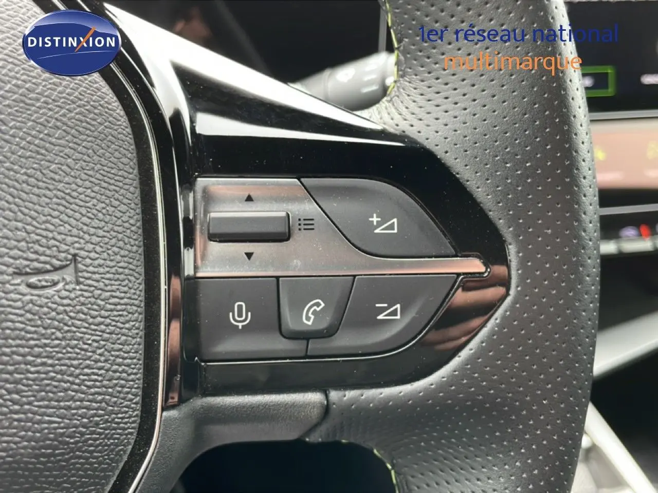 Gros plan sur les commandes multifonctions du volant en cuir perforé noir du Peugeot 408 Hybrid 145ch GT 2024.