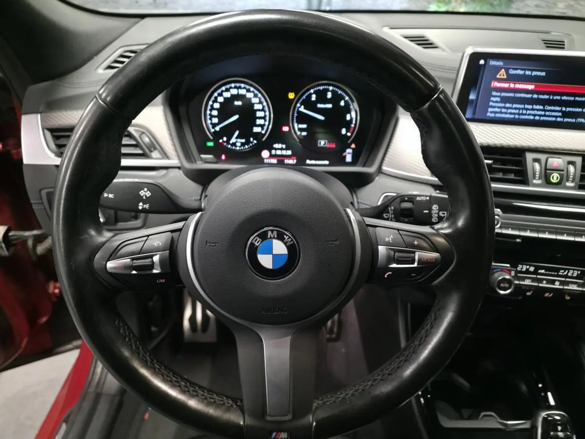 Vue rapprochée du volant M en cuir noir et du tableau de bord numérique d'une BMW X2 2021.